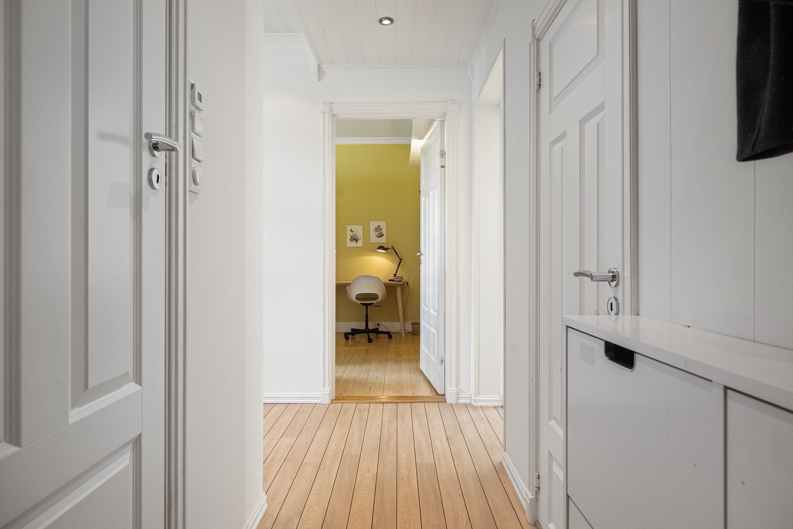 Entréen er innredet med et vegghengt skoskap samt knaggrekke som gir en praktisk løsning for oppbevaring av yttertøy og sko, og bidrar til et ryddig og funksjonelt inngangsparti Galleribilde