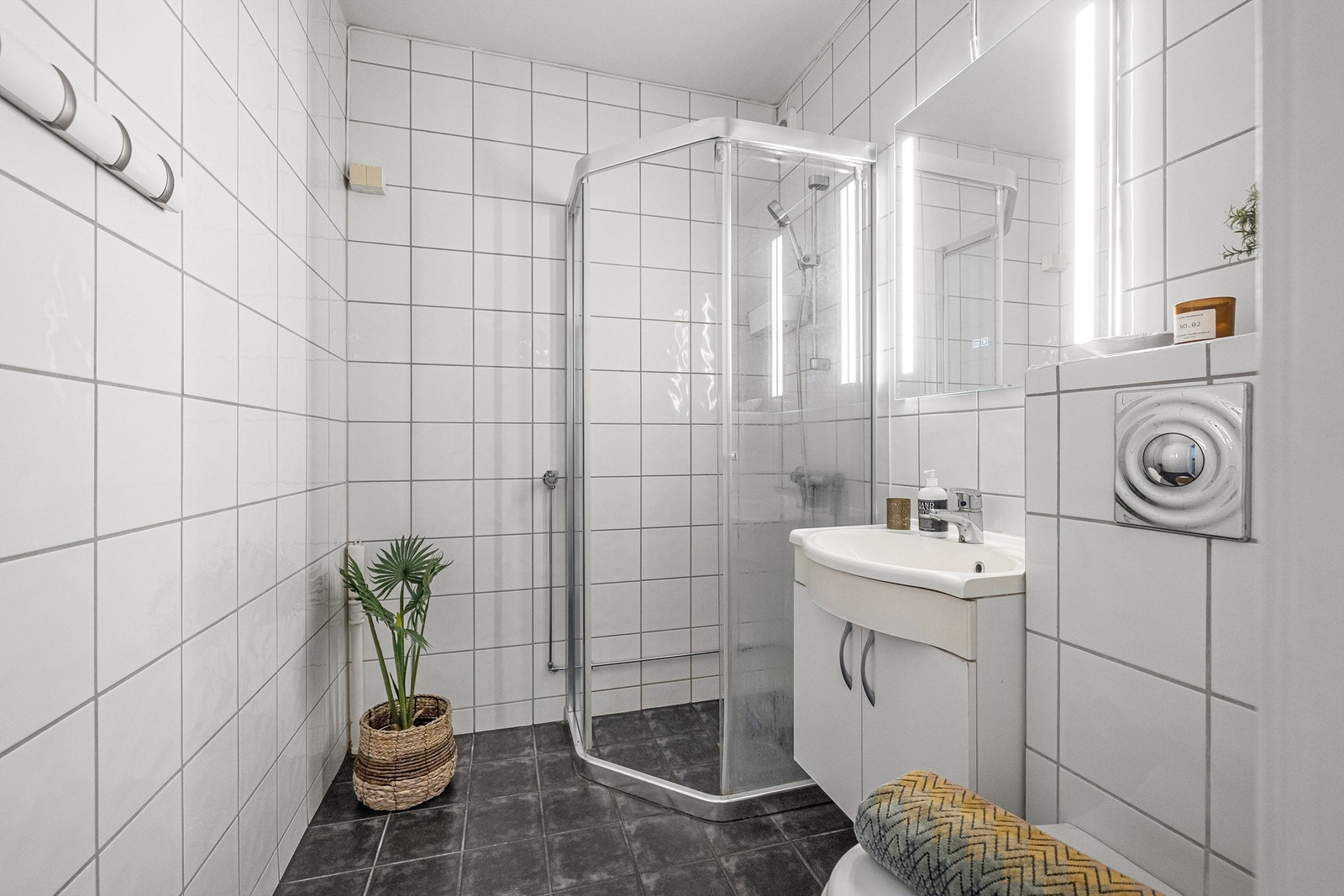 Badet er fra 2008 og er pent flislagt på gulv og vegger med varme i gulvet. Innredningen består av vegghengt servantskap med servant. Over servanten er det speil og belysning. Galleribilde