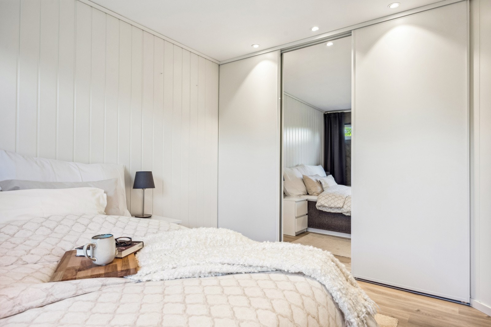 Det er gode oppbevaringsmuligheter i en stor skyvedørsgarderobe. Galleribilde
