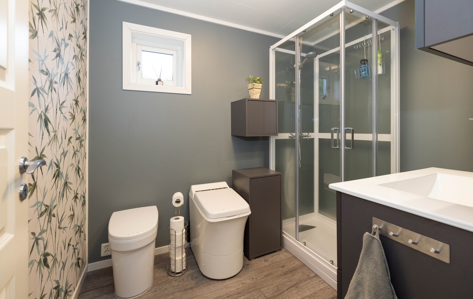 Et romslig bad med forbrenningstoalett, urinovatoalett og dusjkabinett Galleribilde