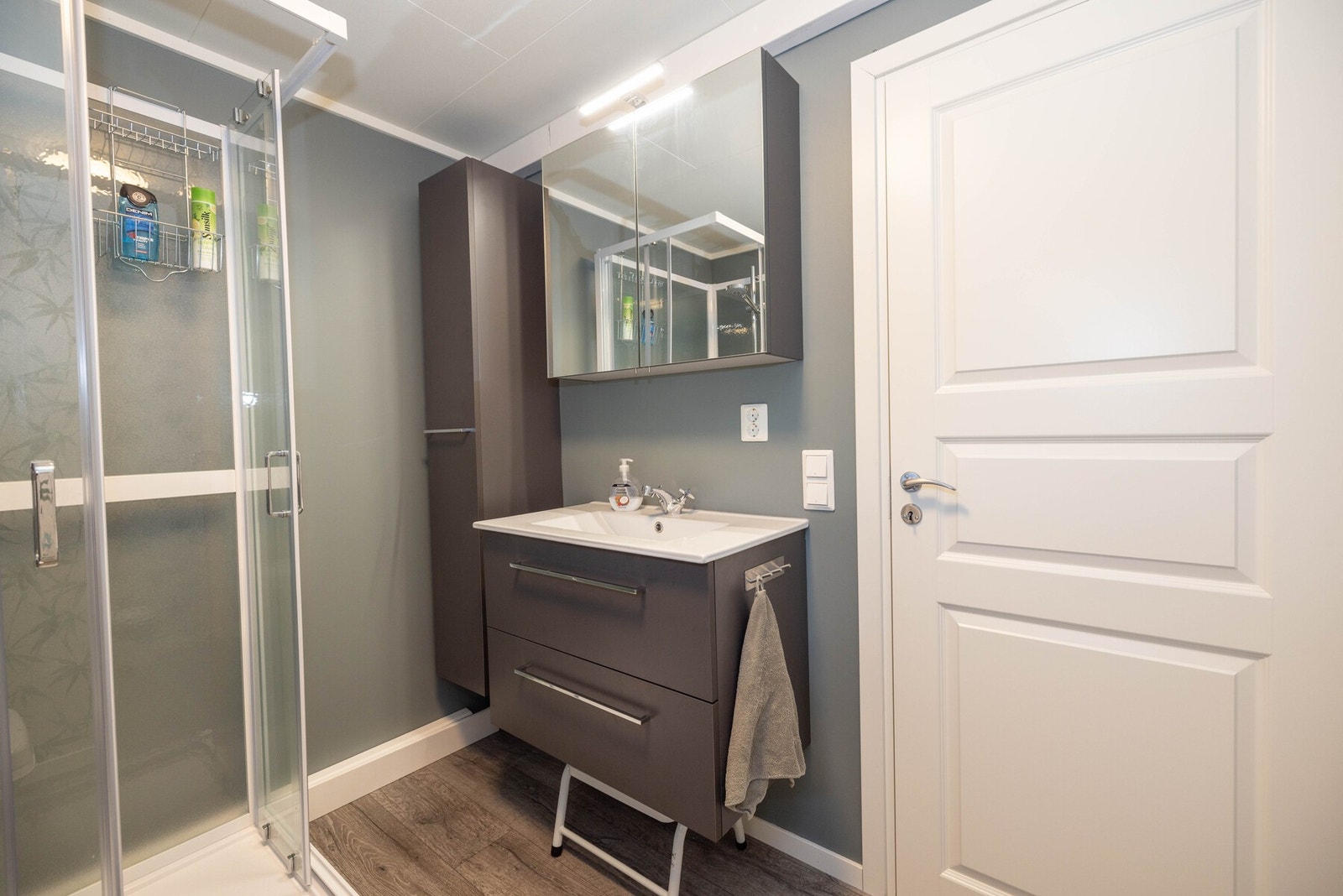 Badet inneholder innredning med skuffer, skap og speilskap med belysning Galleribilde