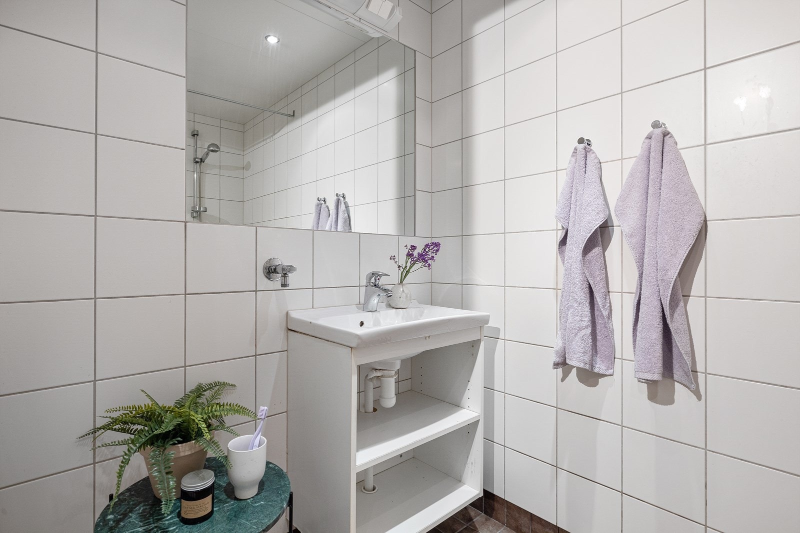Badet består av baderomsinnredning med servant og skap, dusjhjørne og toalett. Det er opplegg for vaskemaskin Galleribilde