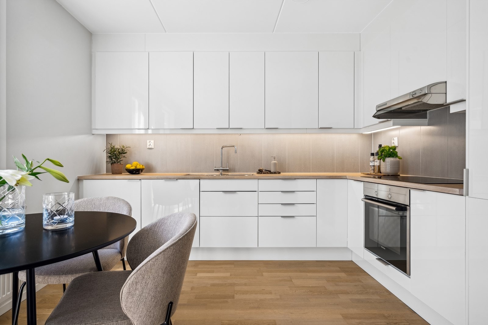 Det romslige kjøkkenet har takhøy innredning med god skap- og benkeplass. Heltre, hvitpigmentert benkeplate som står godt til gulvet. Alle hvitevarer på kjøkken medfølger ved salg Galleribilde