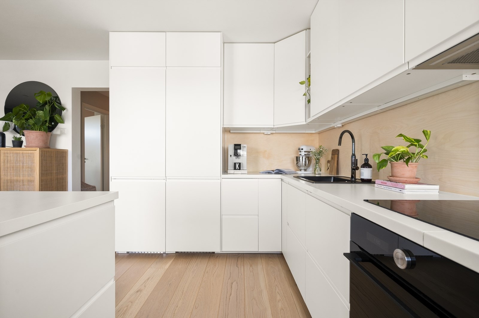 Kjøkkeninnredning med glatte fronter, laminert benkeplate og bjørkefiner plater impregnert med hardvoks. Stort integrert fryseskap og kjøleskap for ekstra god lagring av matvarer. Galleribilde