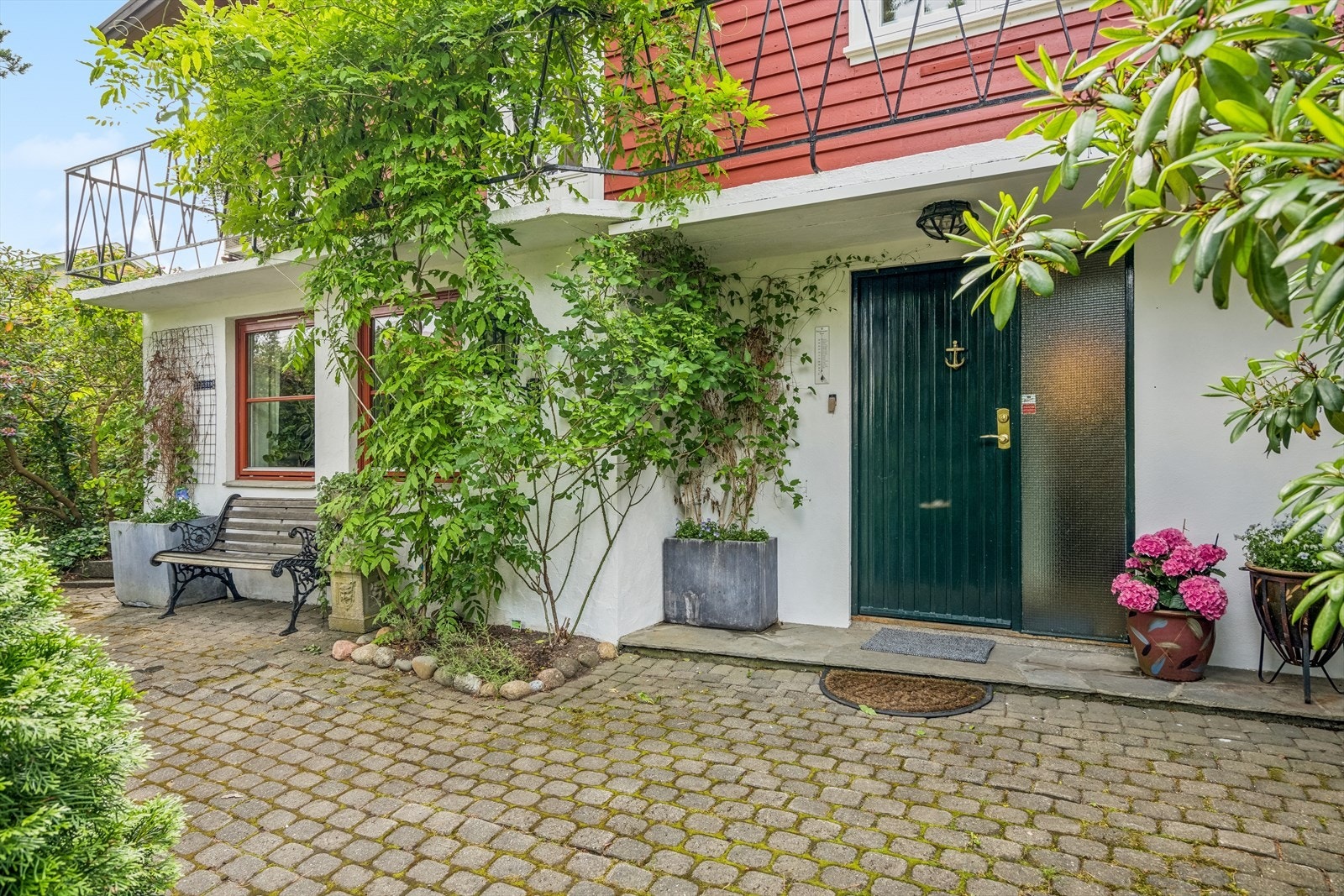 Foran inngangspartiet er det pent beplantet og det er lagt belegningsstein samt skifer. Galleribilde