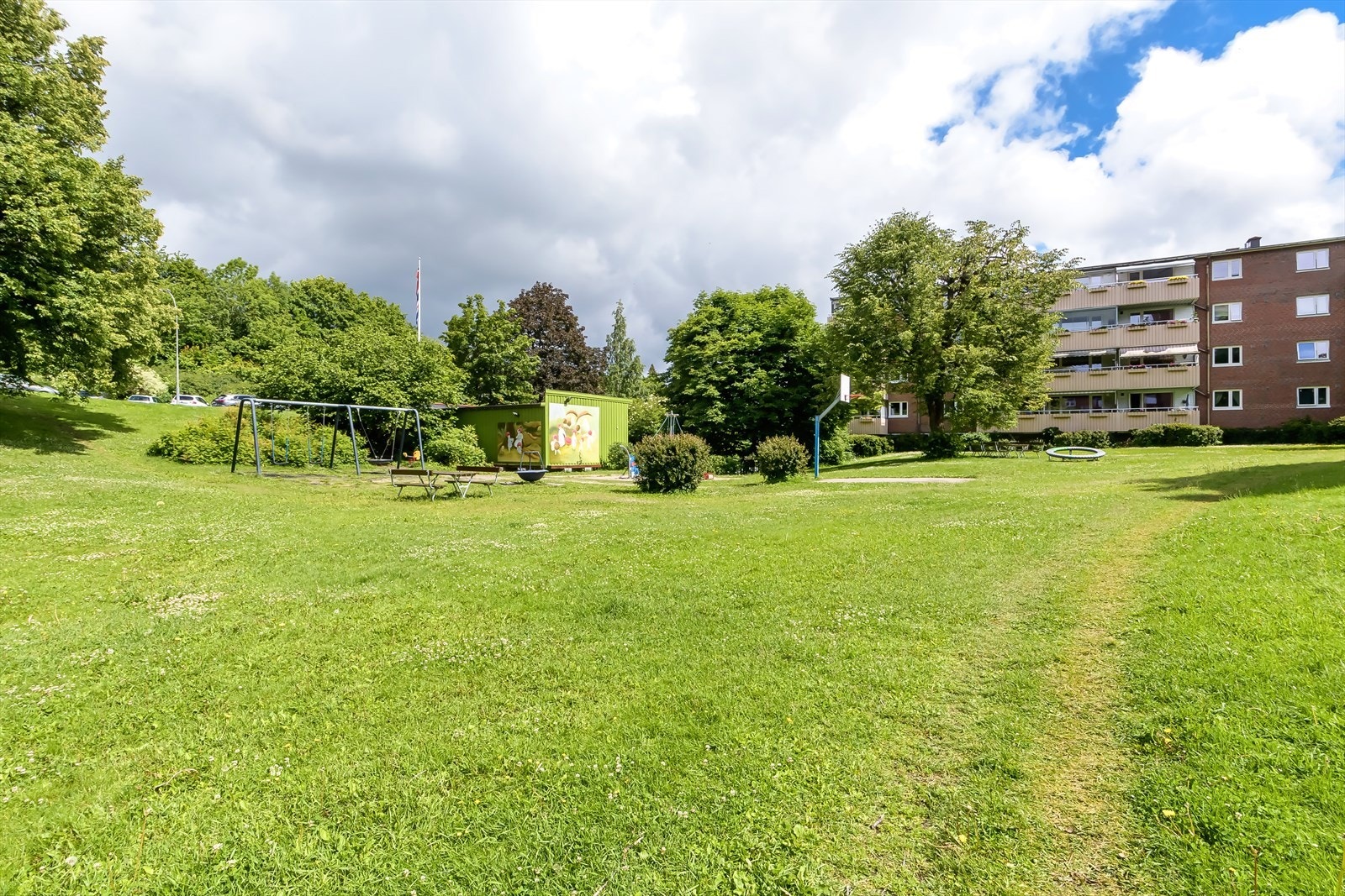 Pent opparbeidede fellesarealer med lekestativ, sitteplasser og beplantning Galleribilde