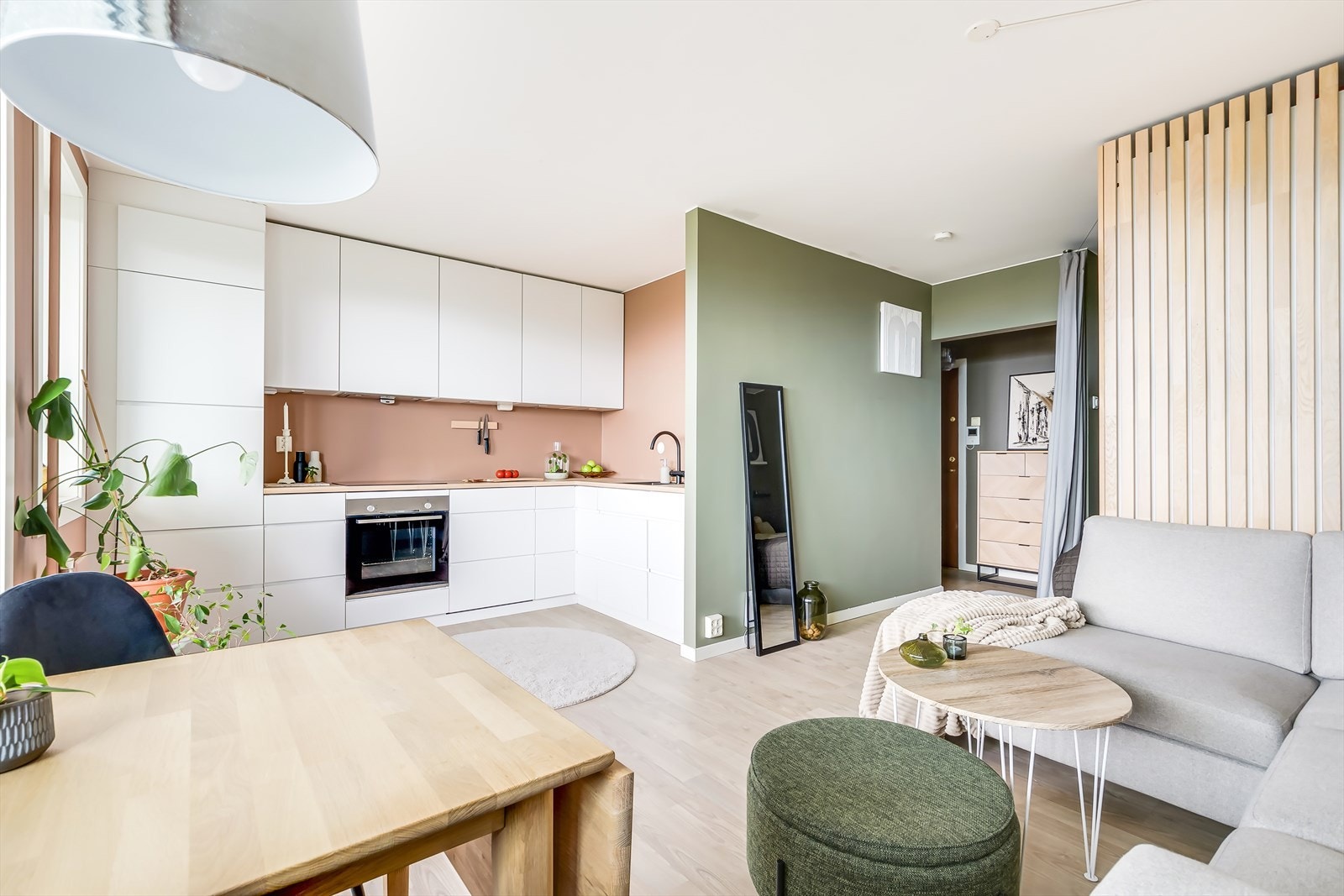 Stuen er i en sosial, åpen løsning med kjøkkenet, som har masse skap og benkeplass Galleribilde