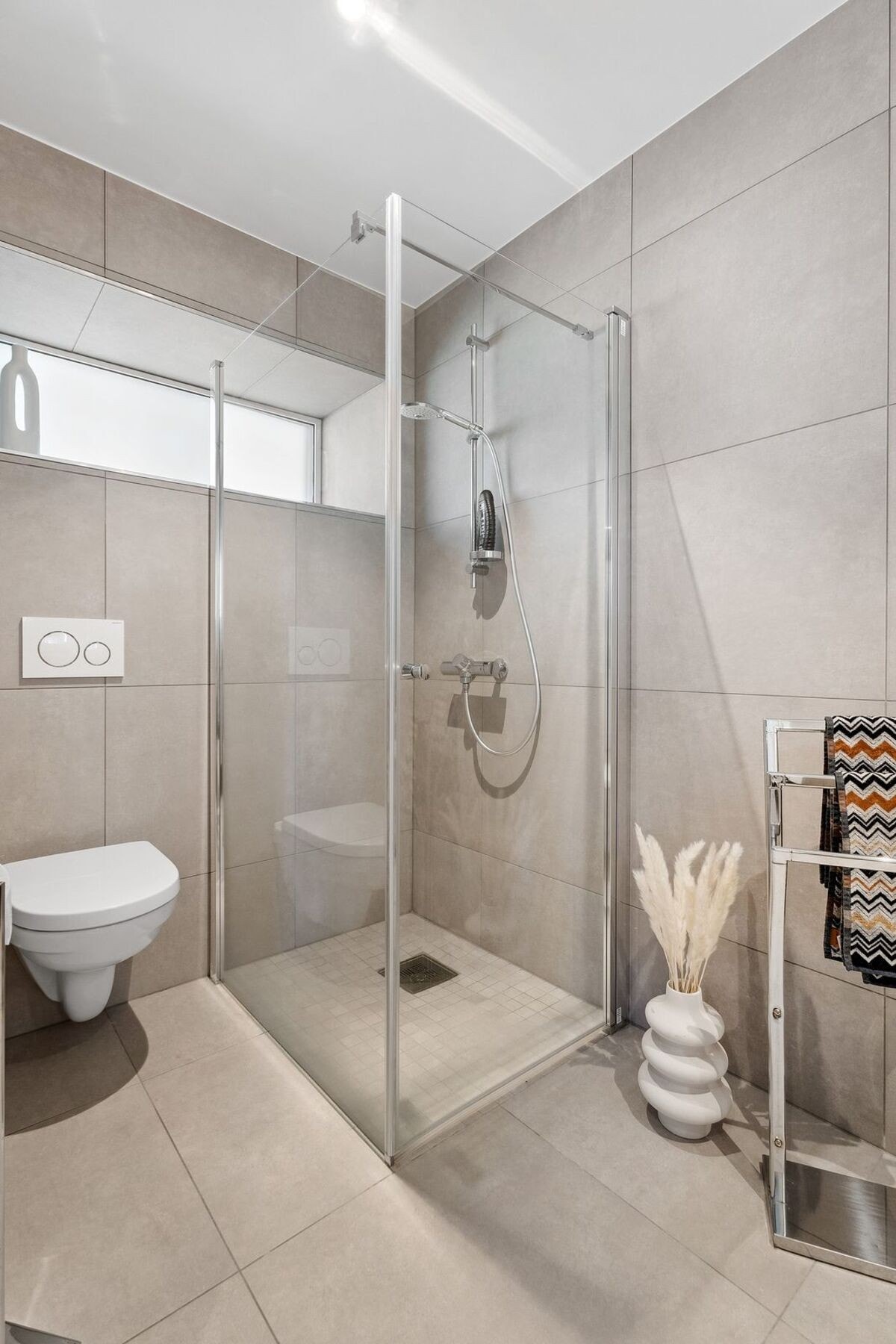 Beige fliser gir et lun følelse på badet. Galleribilde