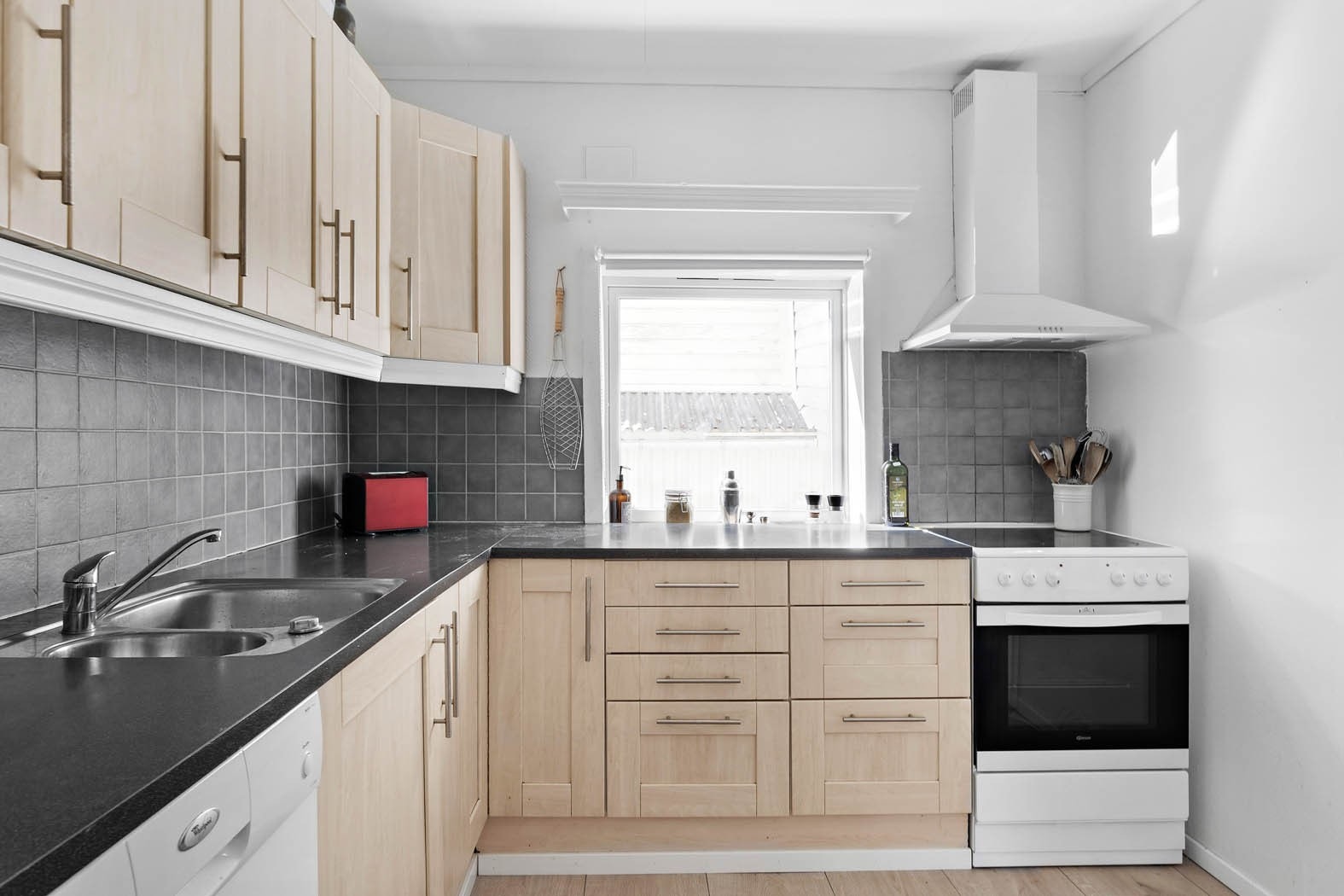 Delikat kjøkkeninnredning med god skap- og benkeplass Galleribilde