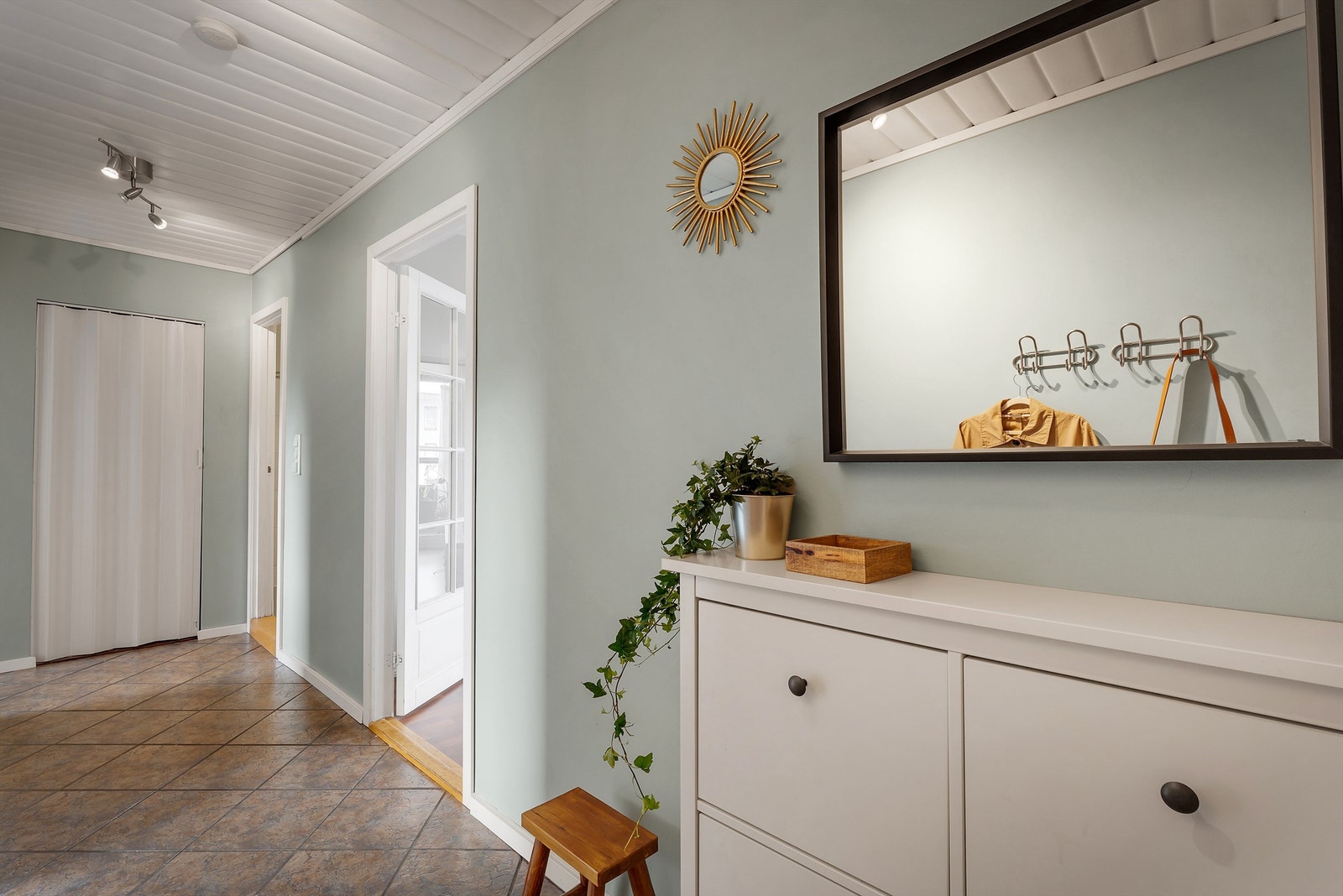 Stor entrè med garderobe/ lagringsplass i enden Galleribilde