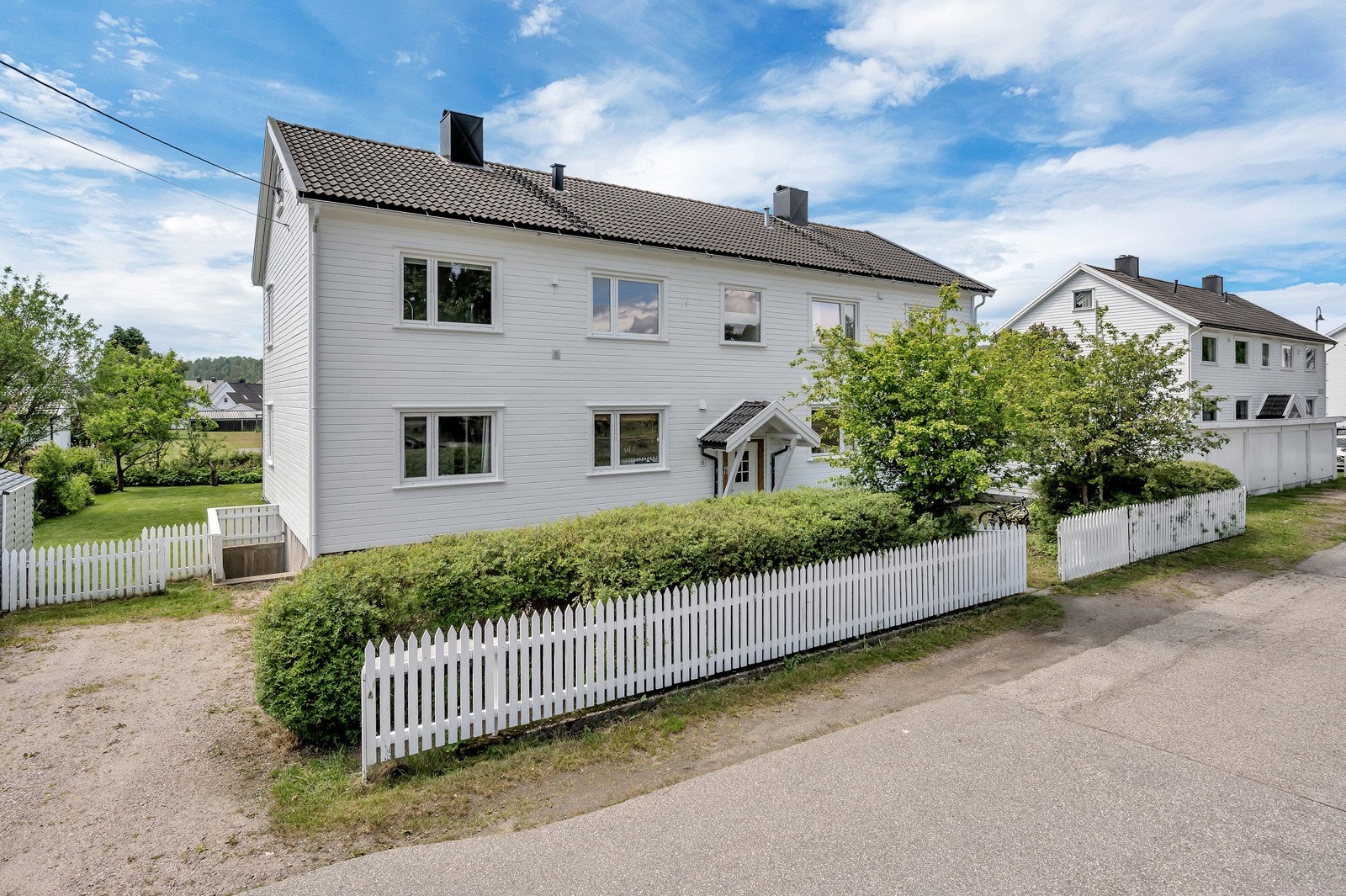 Felles tomt innrammet med hvitt stakittgjerde Galleribilde