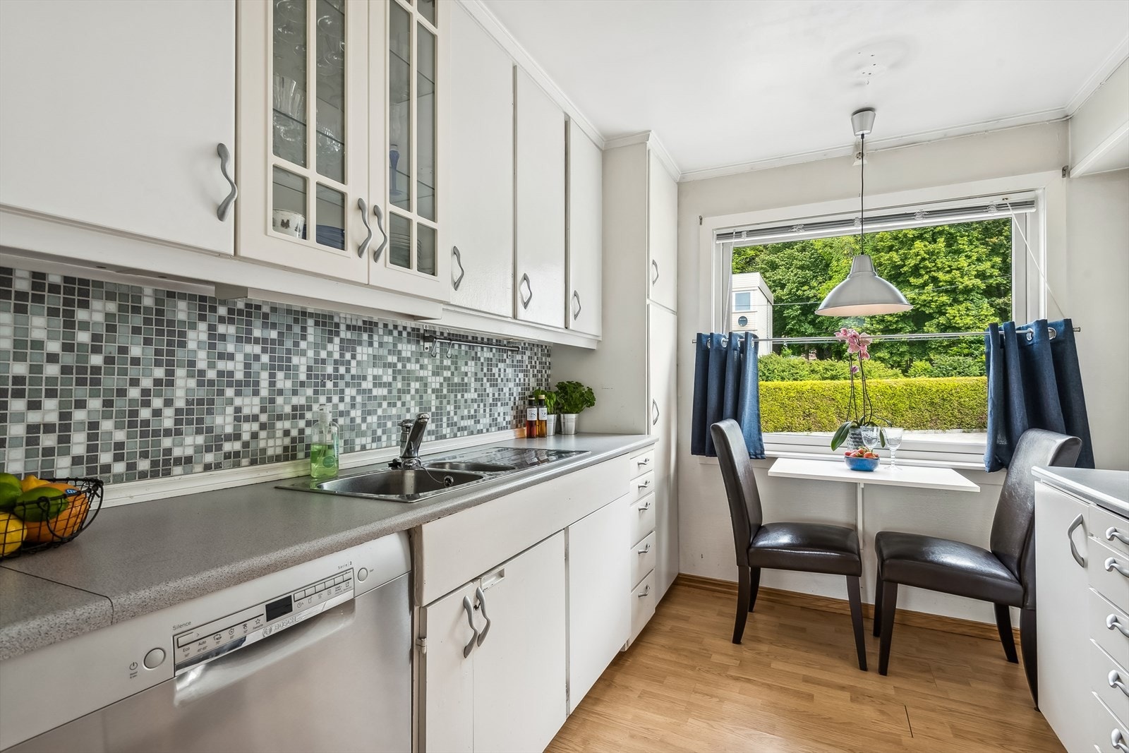 Kjøkkenet er av eldre standard men har godt med oppbevaringsplass. Det er plass til frokostbord ved vinduet. Galleribilde