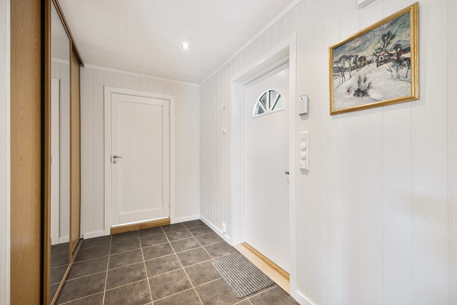 Eneboligen har adkomst via en innbydende entré/gang med skyvedørsgarderobe, gulvvarme og downlights. Galleribilde