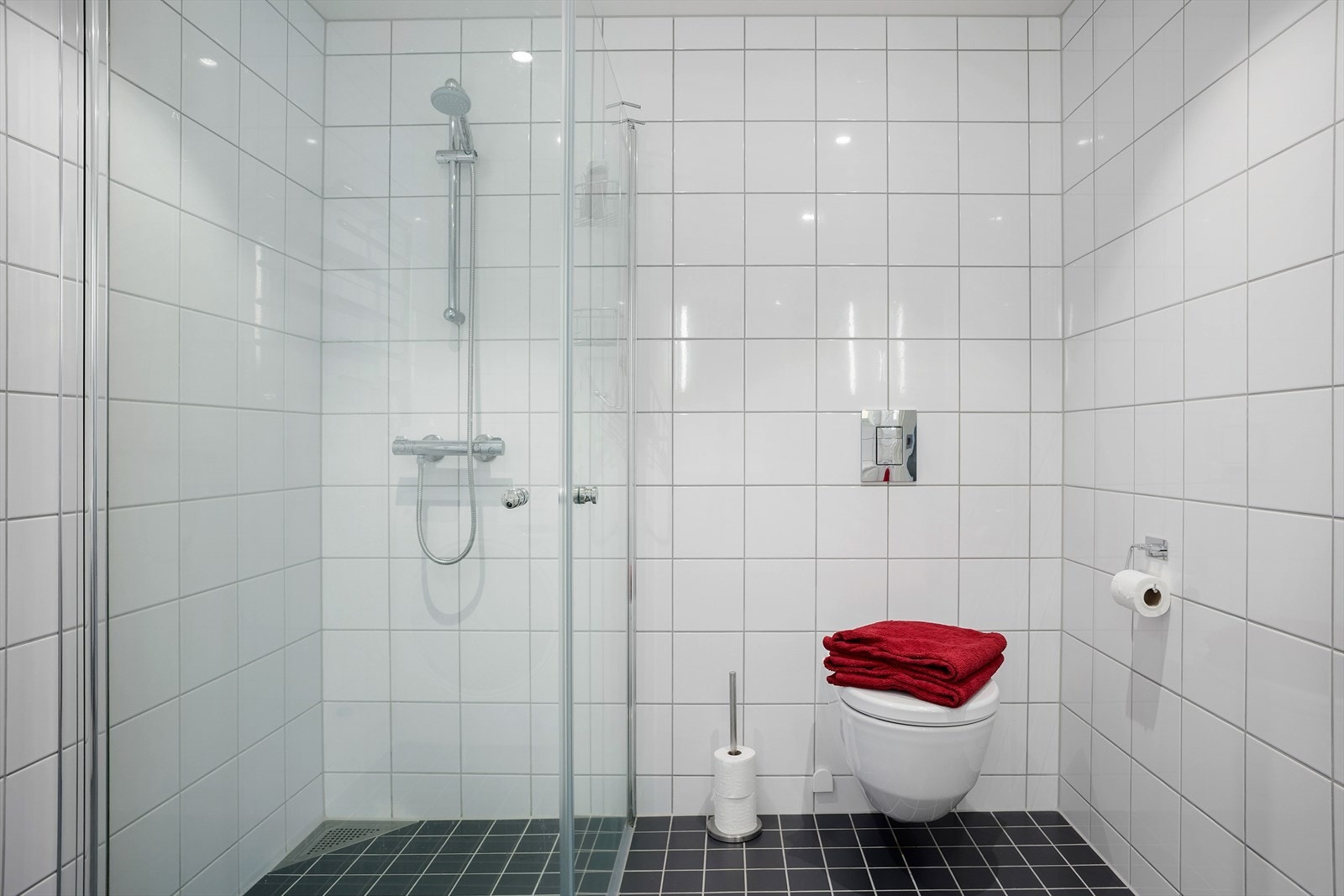 Dusjnisje, vegghengt toalett og stor baderomsinnredning . Opplegg for vaskemaskin. Galleribilde