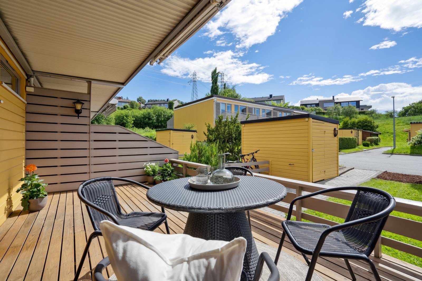 Terrassen foran husets inngangsparti huset måler 15 kvm og har gode solforhold store deler av dagen. Andelen disponerer også en redskapsbod på 3 kvm som man ser foran huset på bildet. Galleribilde