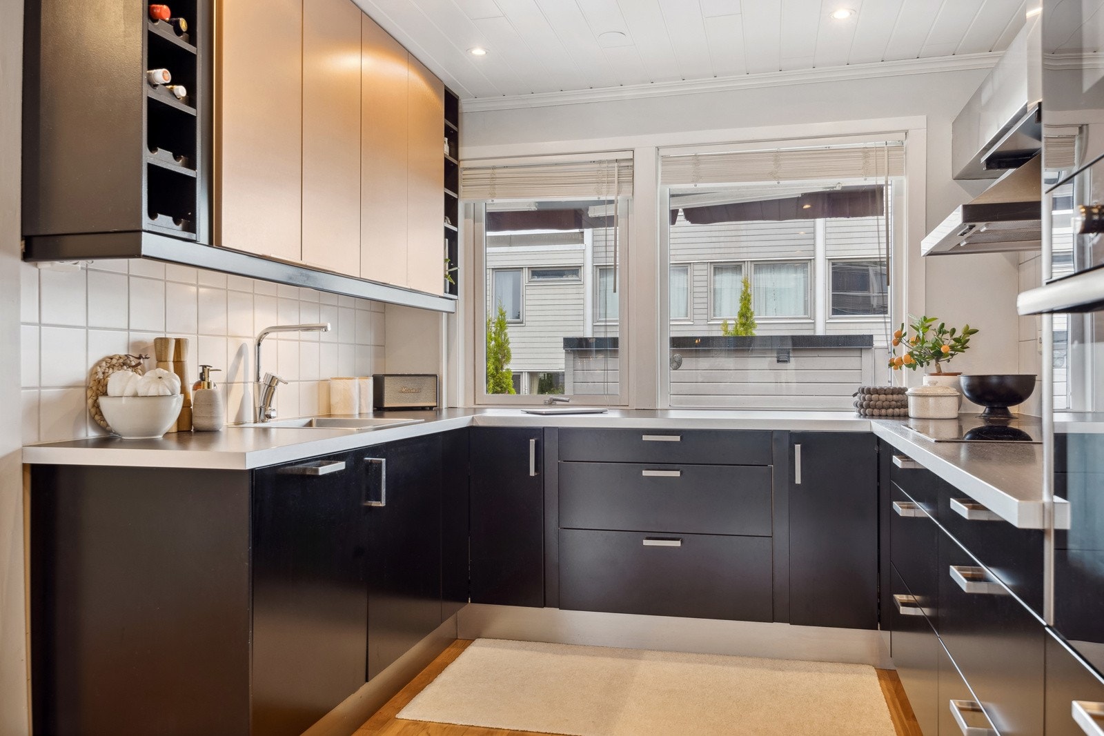 Her har man godt med skap- og benkeplass og fin oversikt over fremsiden og terrassen. Detaljer som downlights, flis over kjøkkenbenk og integrerte hvitevarer gjør rommet praktisk i hverdagen. Galleribilde