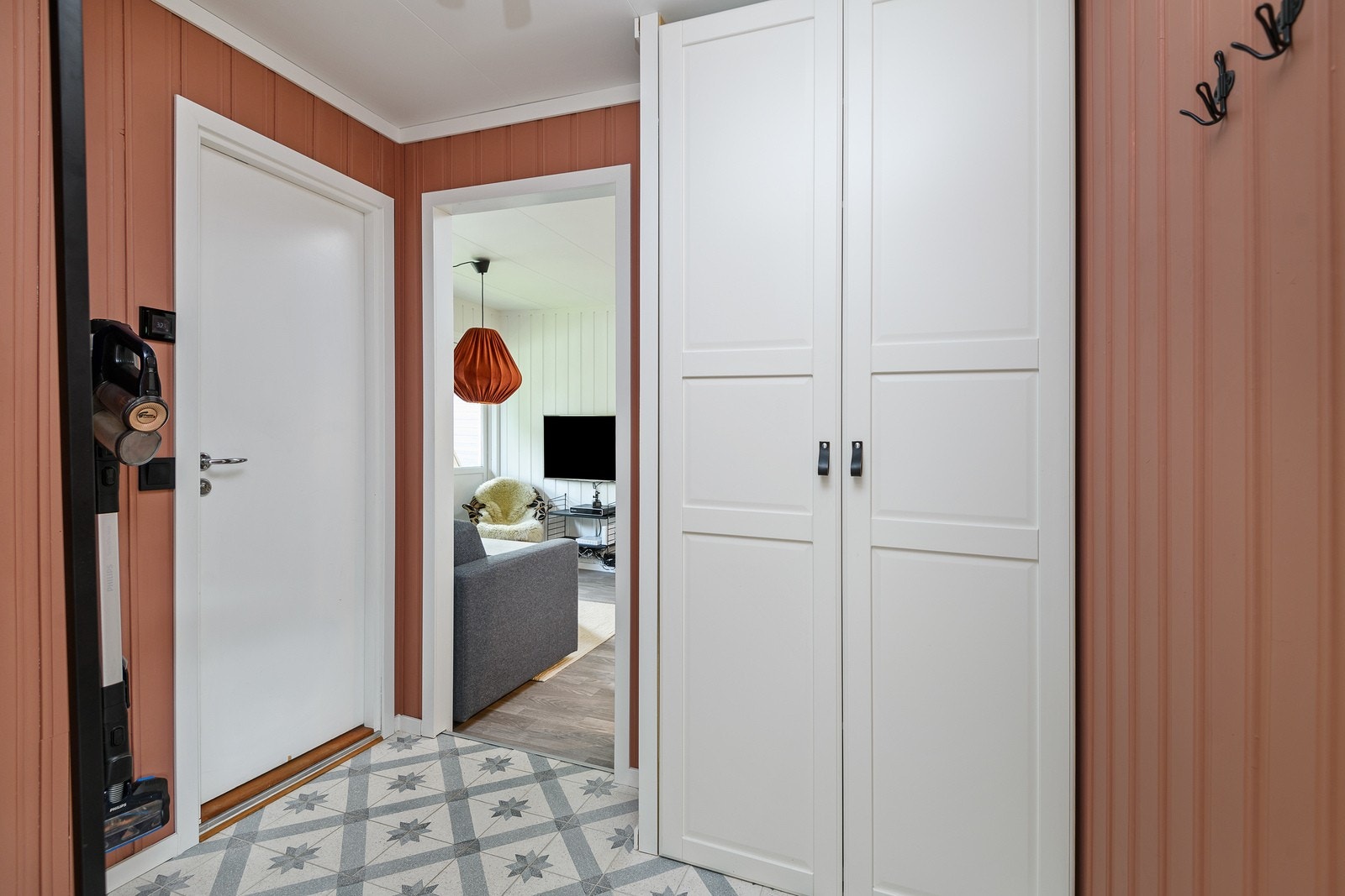 Vel innenfor døren er det en modernisert entré med malt panel på vegger og sementfliser på gulv. Galleribilde