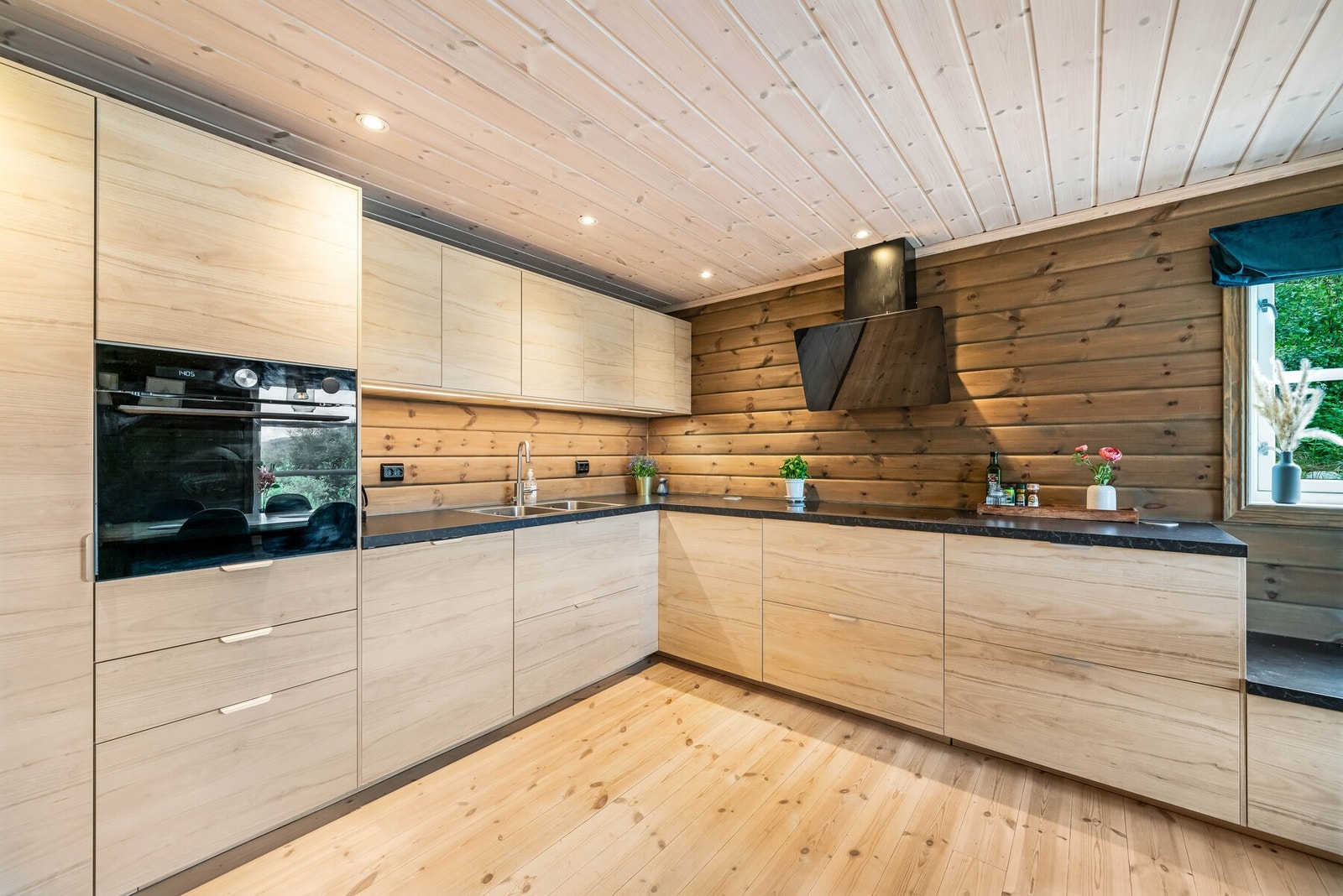 Innredningen har slette fronter i trestruktur og laminert benkeplate. Nedfelt platetopp og oppvakskum. Kjøleskap, komfyr og oppvaskmaskin er integrerte i innredningen. Frittstående ventilator i sort utførelse. Galleribilde