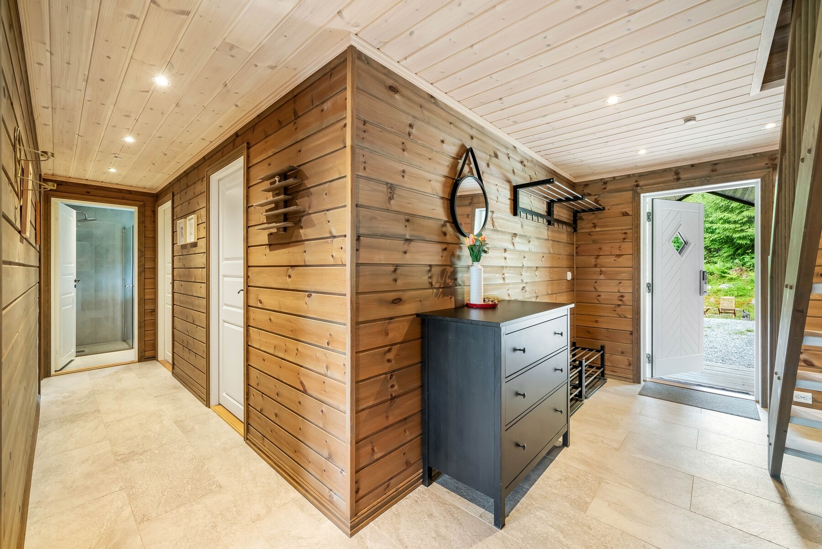 Velkommen inn! Flislagt entrè med varmekabler som leder inn til stue via åpen portal. Galleribilde