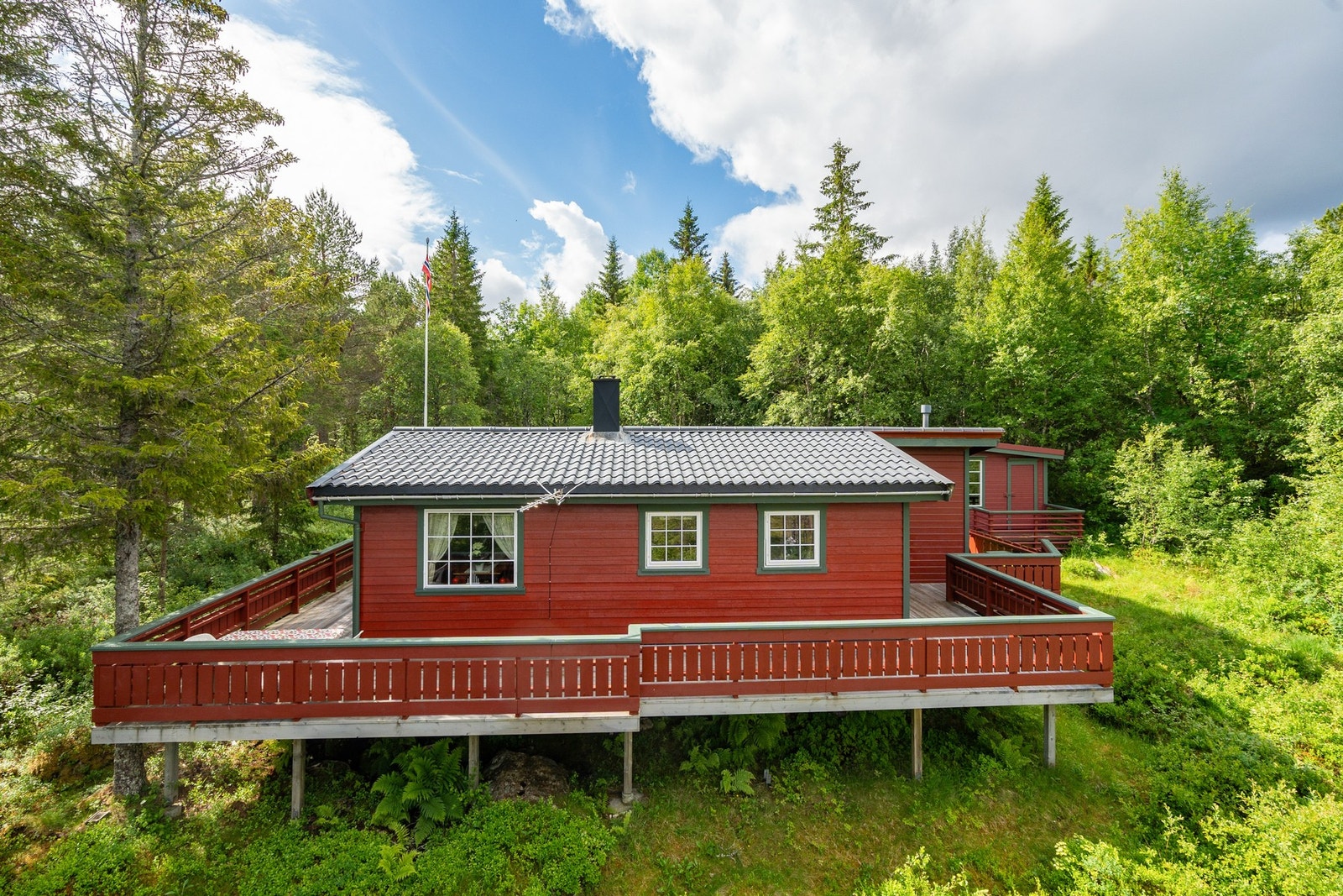 Stor terrasse som går rundt hytta Galleribilde