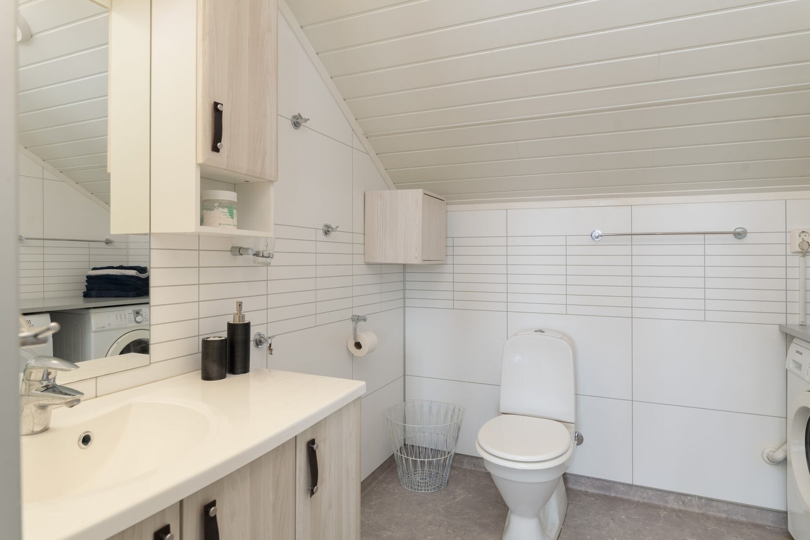 Bad/vaskerom er utstyrt med servant på innredning, toalett og dusjkabinett Galleribilde