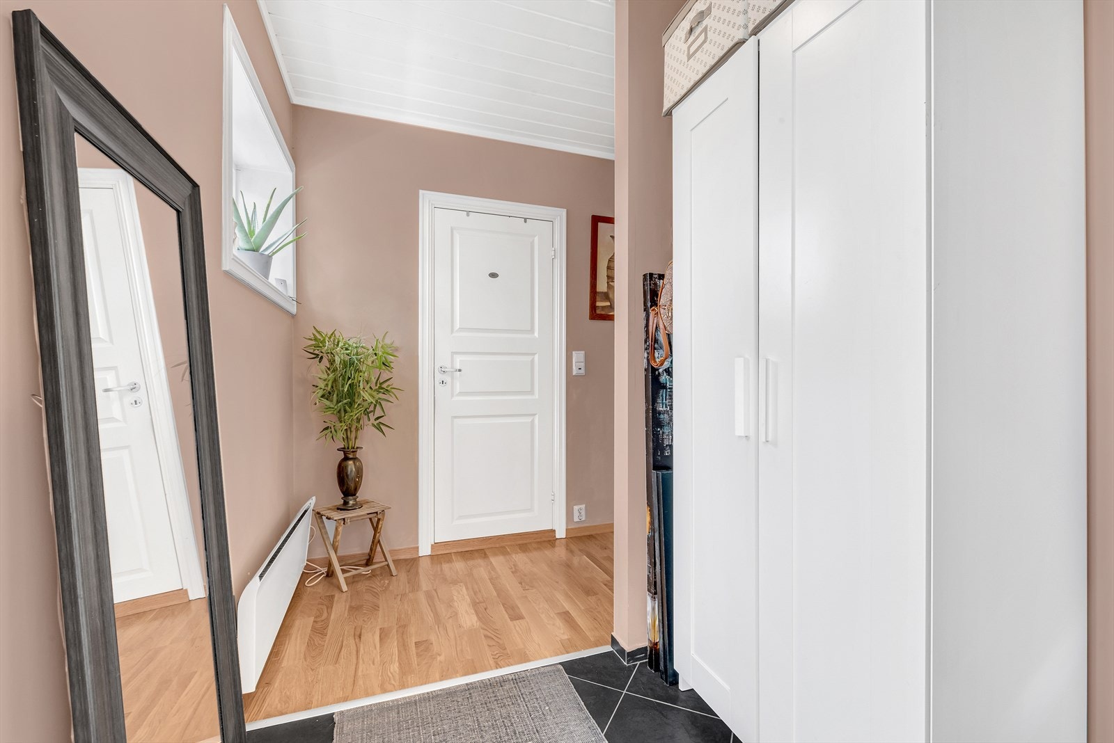 Velkommen! Leiligheten har egen inngang, og her trer du inn i en innbydende entré med fliser på gulv. Galleribilde