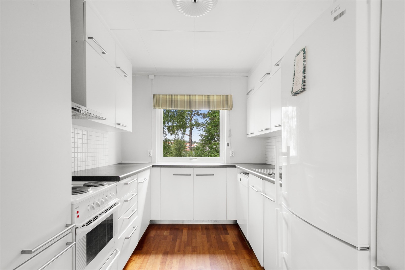 Kjøkkenet har flere arbeidssoner og godt med oppbevaringsplass i over-, under- og høyskap. Her kan både store og små lage mat! Galleribilde