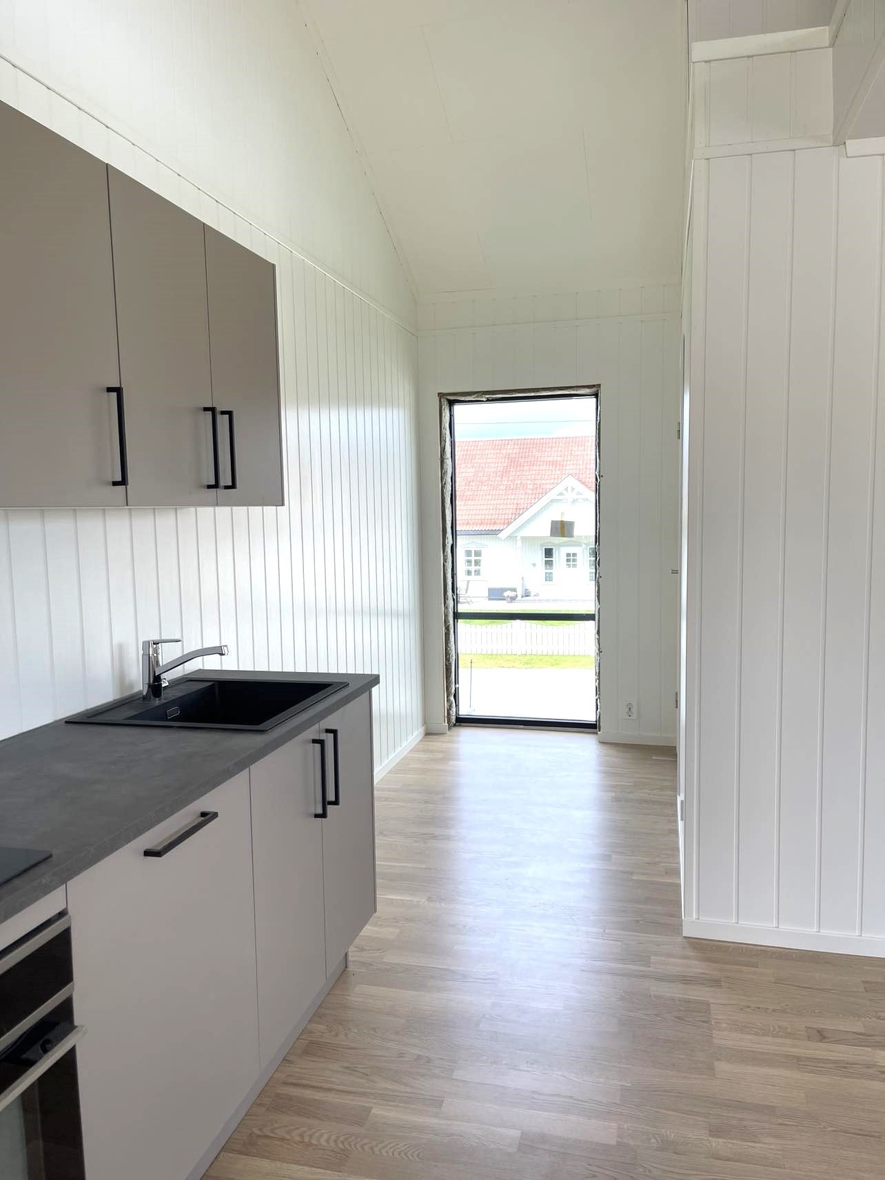 Åpen stue-kjøkkenløsning - integrerte hvitevarer er inkludert Galleribilde