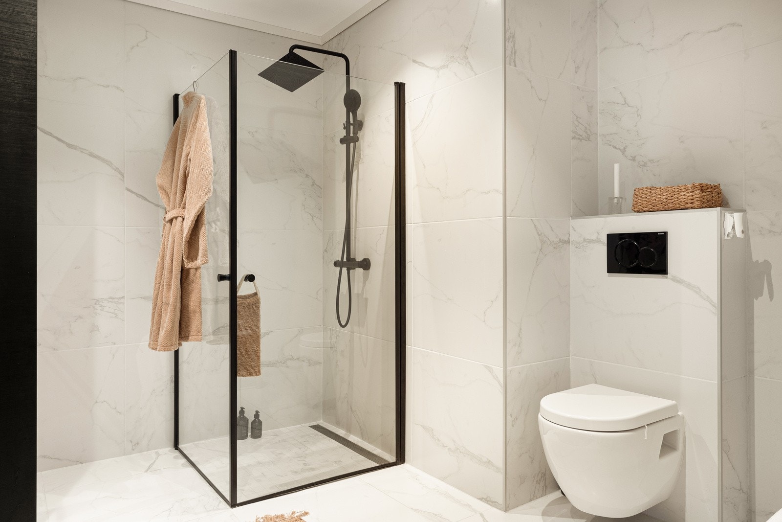 Badet er innredet med baderomsmøbel, speil, dusj og vegghengt toalett. Galleribilde