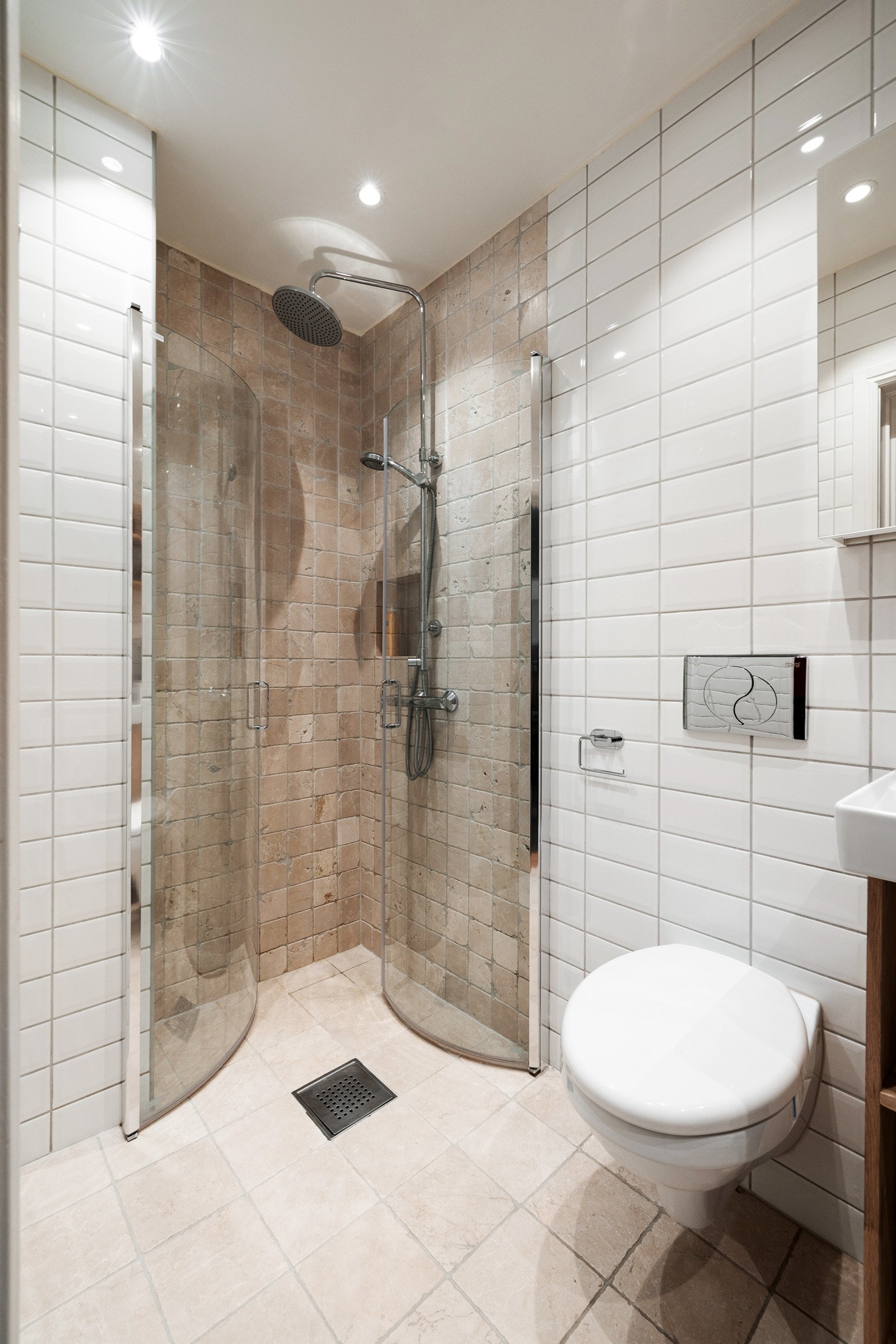 Innbydende og delikat baderom med marmorfliser og romslig dusjhjørne, gulvvarme og vegghengt WC Galleribilde