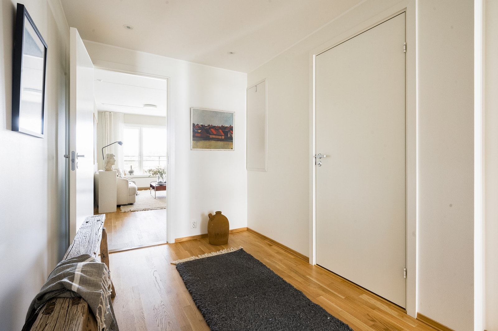 Hvitmalt og romslig entré/gang innredet med god plass til oppbevaringsmøbel etter eget ønske Galleribilde