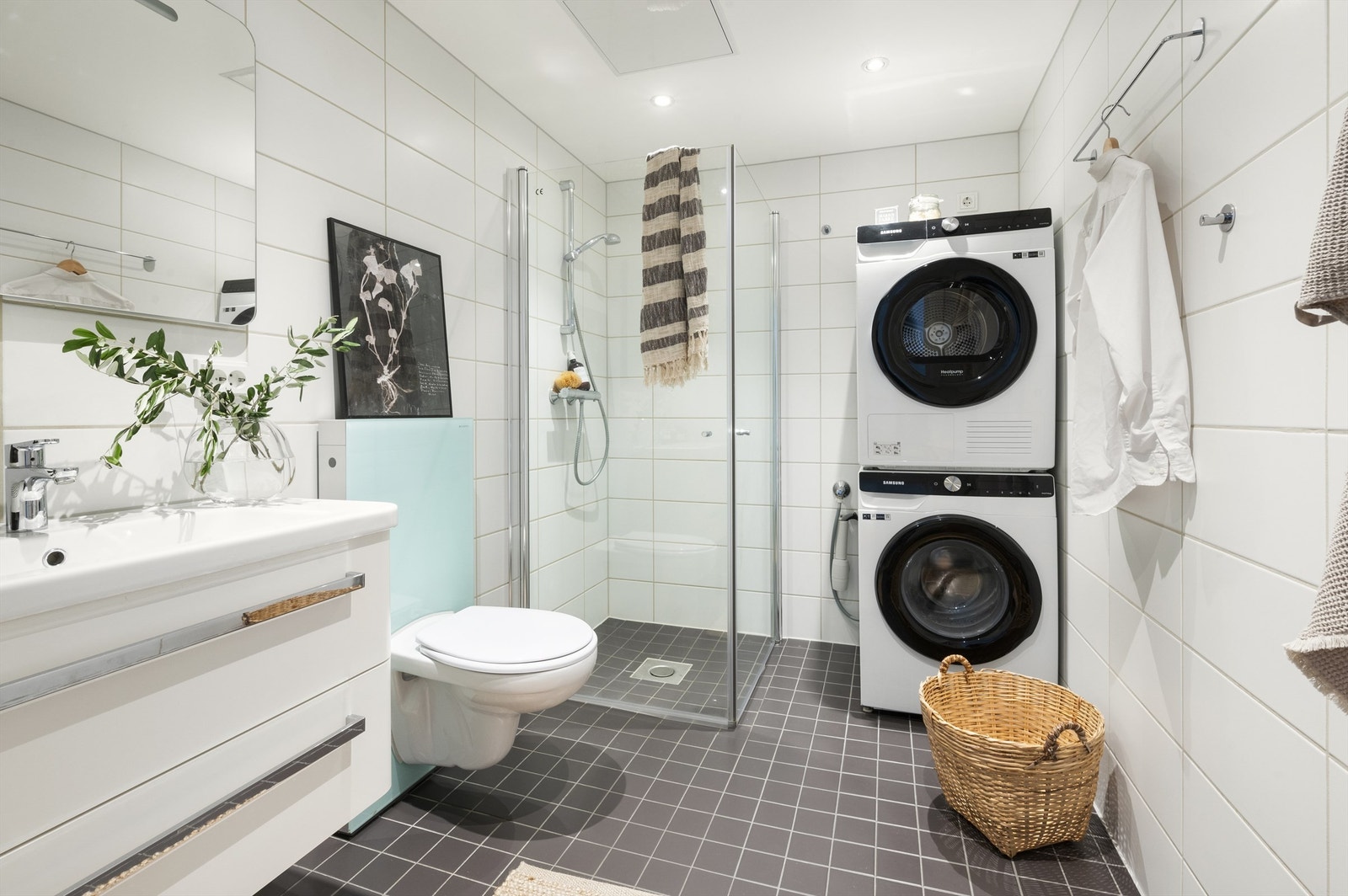 Innbydende og meget romslig bad med hvite fliser på vegg, grå fliser på gulv med varmekabler og downlights i himling Galleribilde