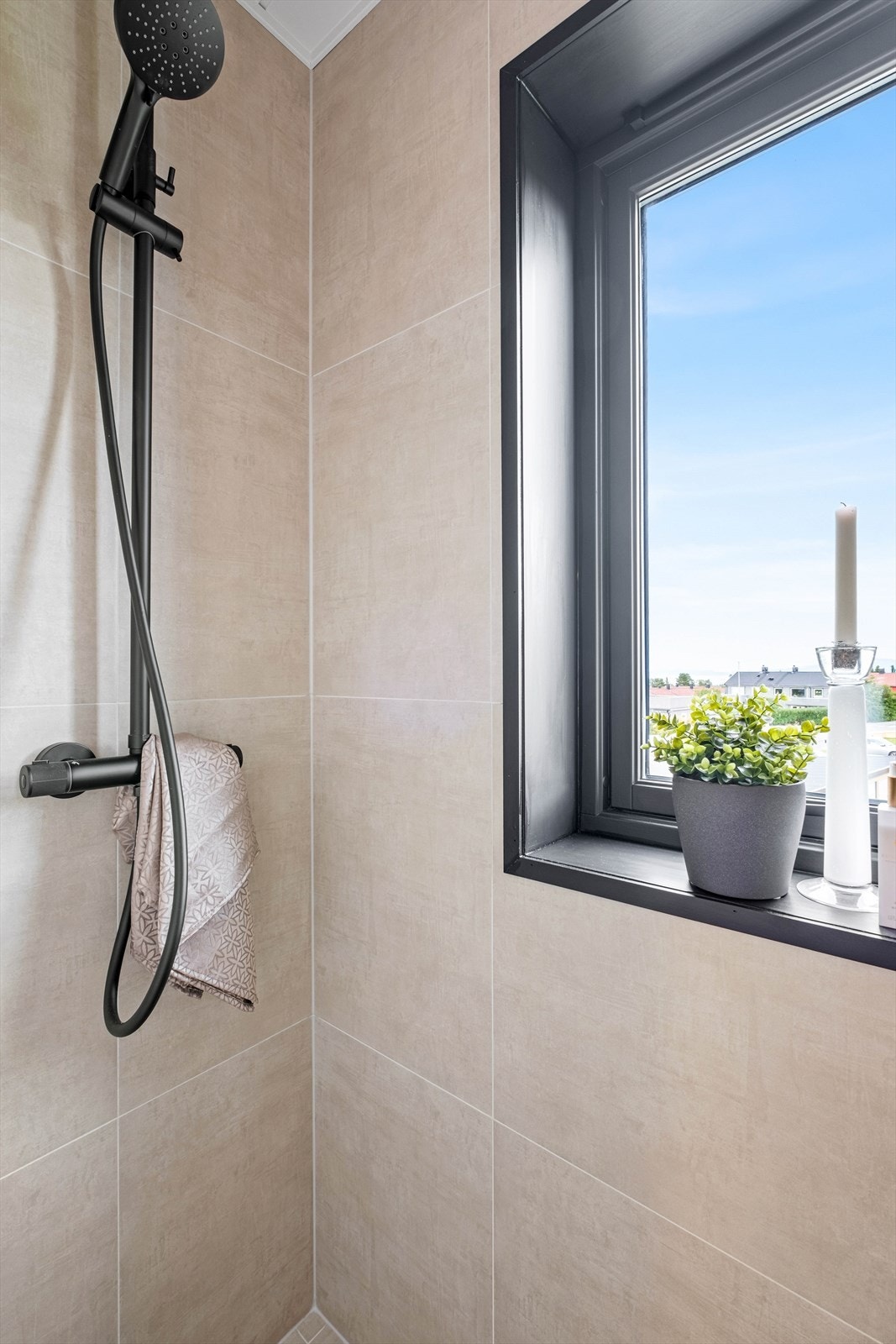 I en smart dusjnisje er det veggmontert, sort dusjarmatur. Galleribilde