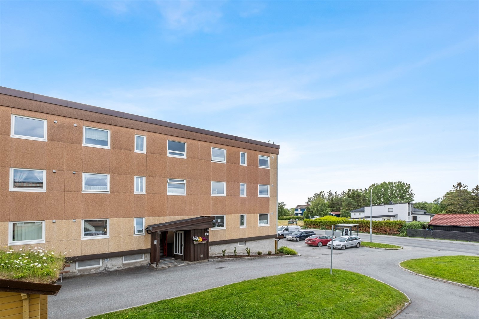 Fellestomten er pent opparbeidet med gressplen og asfalterte internveier. Galleribilde