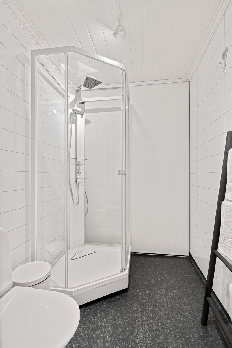 Bak dusjen er det en praktisk skyvedør som skjuler opplegg til vaskemaskin og tørketrommel - meget praktisk! Galleribilde