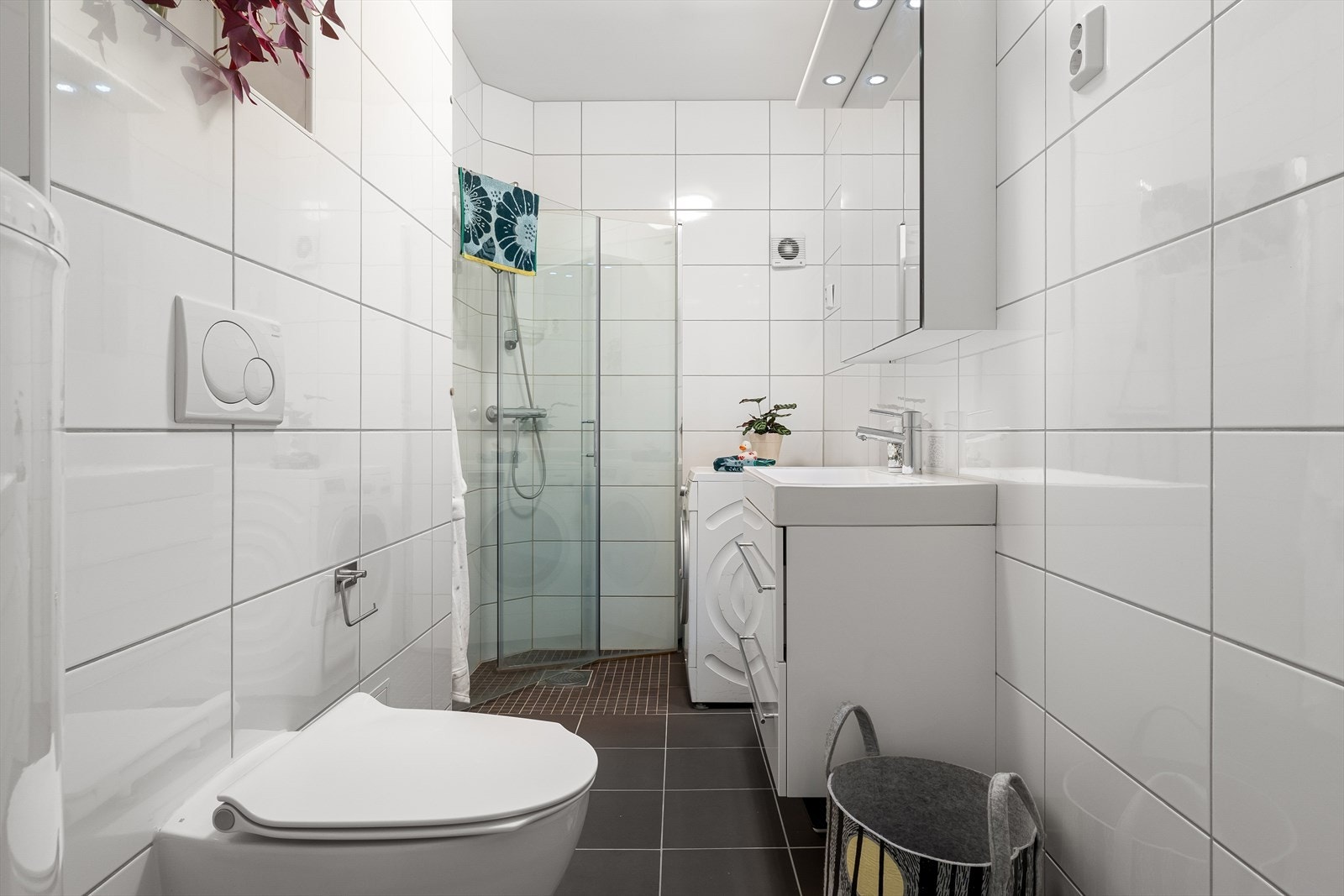 Badet er innredet med toalett, dusjnisje og vask med innredning og speil Galleribilde