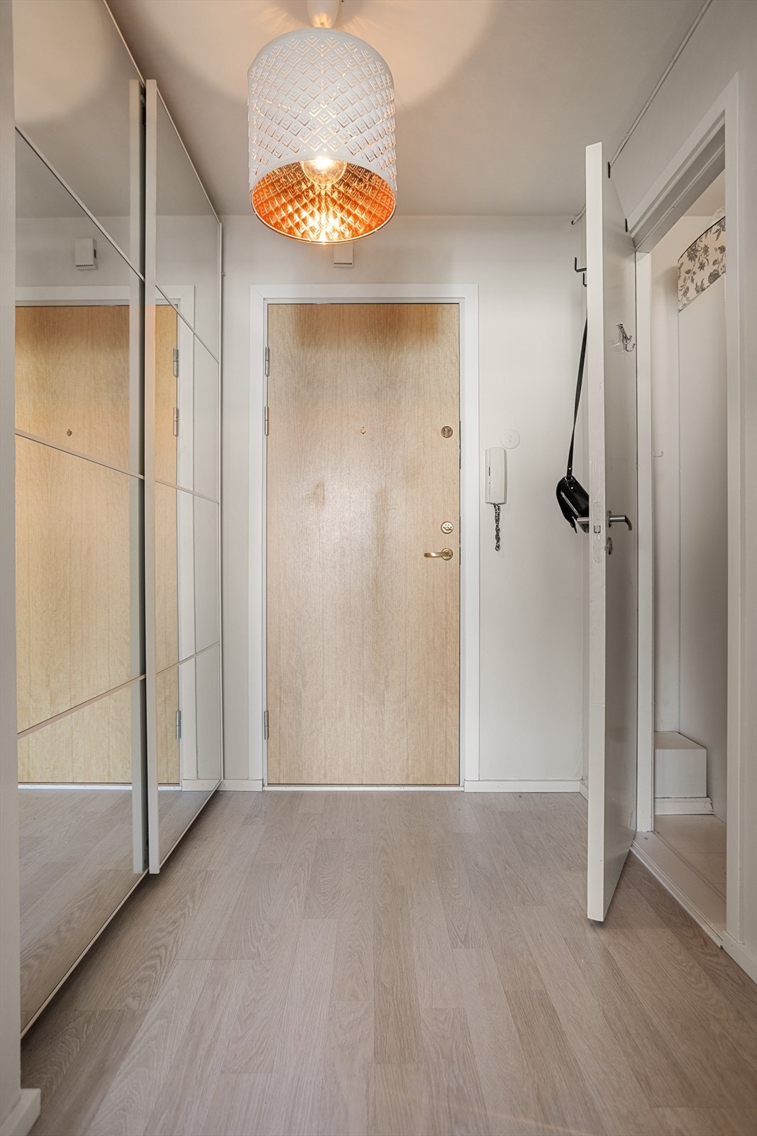 Entréen er utstyrt med skyvedørsgarderobe med speilfronter og dørcallingsystem som gjør det enkelt å slippe inn gjester fra gateplan. Galleribilde