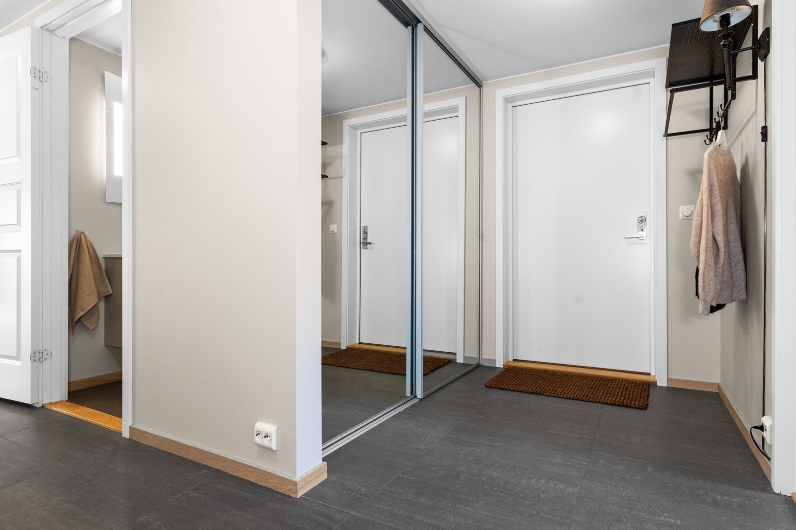 Leiligheten ligger i 1. etasje, har adkomst direkte fra bakkeplan og er bygget med livsløpsstandard. I entréen er det skyvedørsgarderobe med speilfronter. Fliser med varmekabler på gulvet. Galleribilde