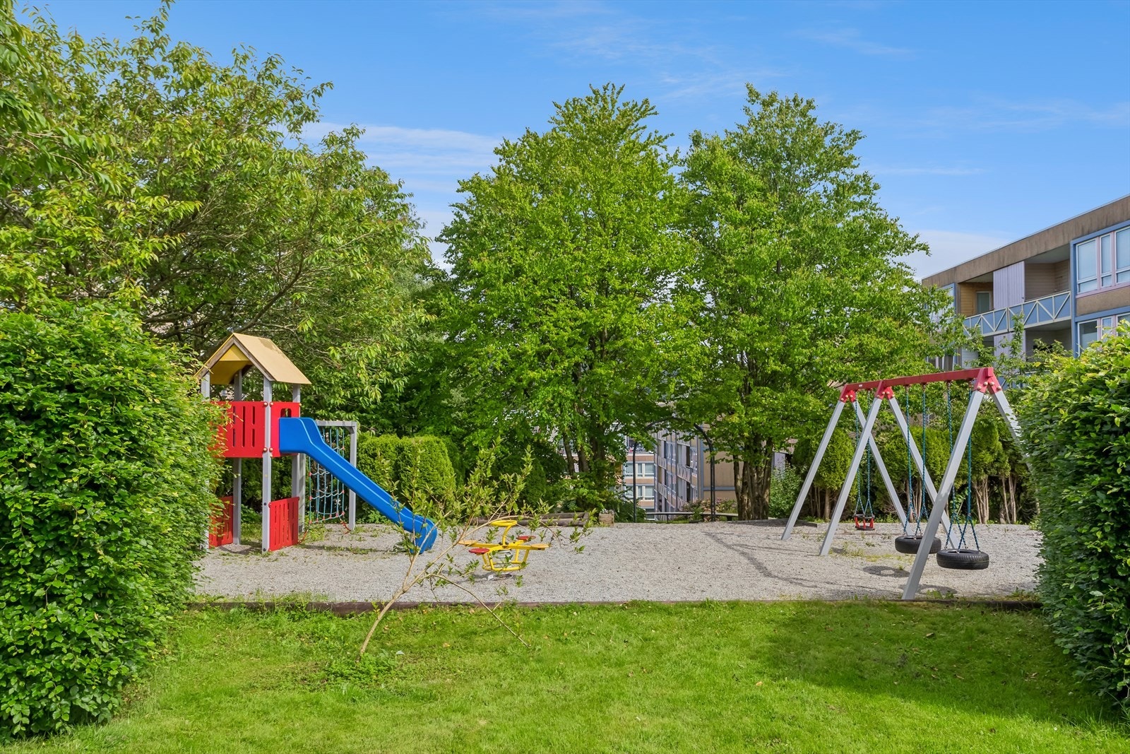 Tomten er pent opparbeidet med gangarealer, gressplener, bed med beplanting og lekeplasser. Galleribilde