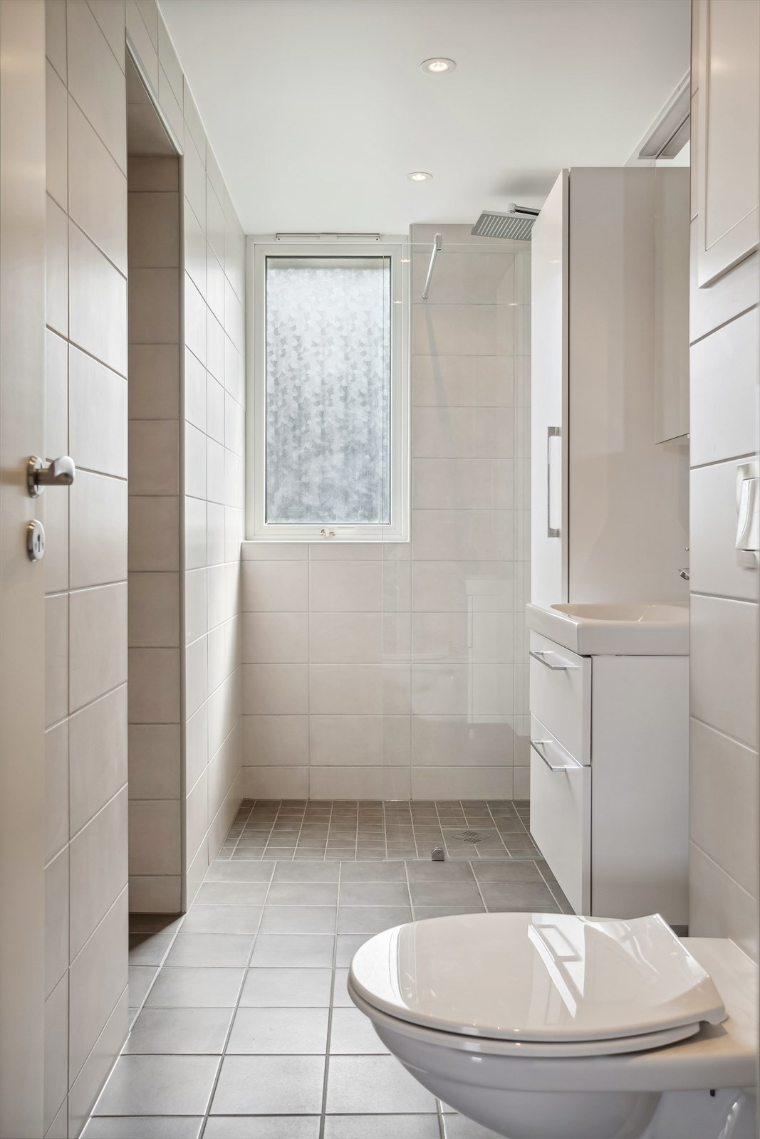 Servant med skapinnredning, dusjsone med glassvegg, vegghengt toalett. Opplegg for vaskemaskin. Galleribilde