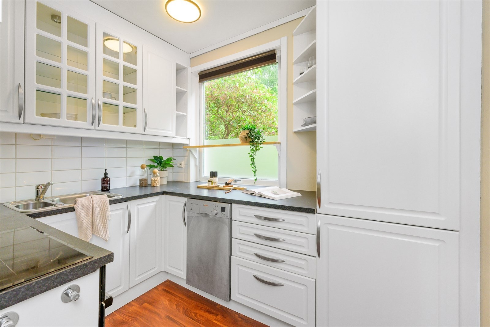 Kjøkken har profilerte fronter med benkeplate av laminat og backsplash i lyse
fliser Galleribilde