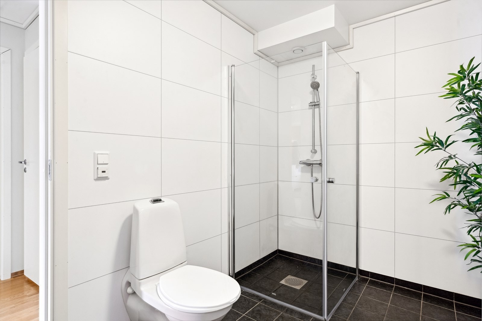 Badet er utstyrt med dusjhjørne, varmekabler og vegghengt toalett. Galleribilde