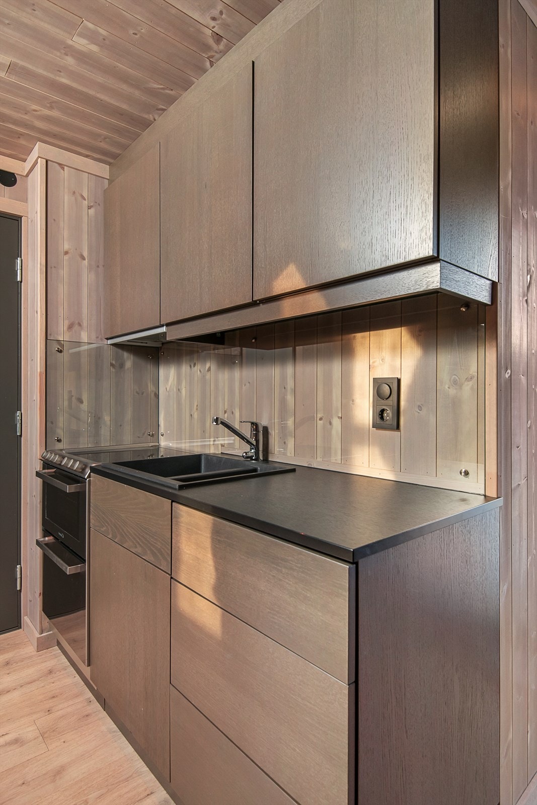 Kjøkkenet er utstyrt med komfyr, oppvaskmaskin og kjøleskap. Det er kjøkkenvifte med avtrekk ut. Galleribilde