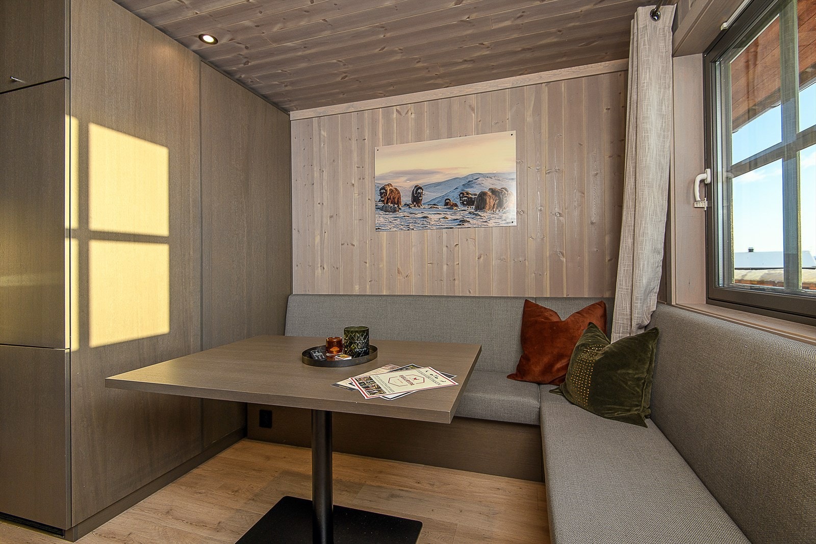 Stuen er lun og trivelig. Det er en praktisk plassbygd sofagruppe med tilhørende bord. Galleribilde