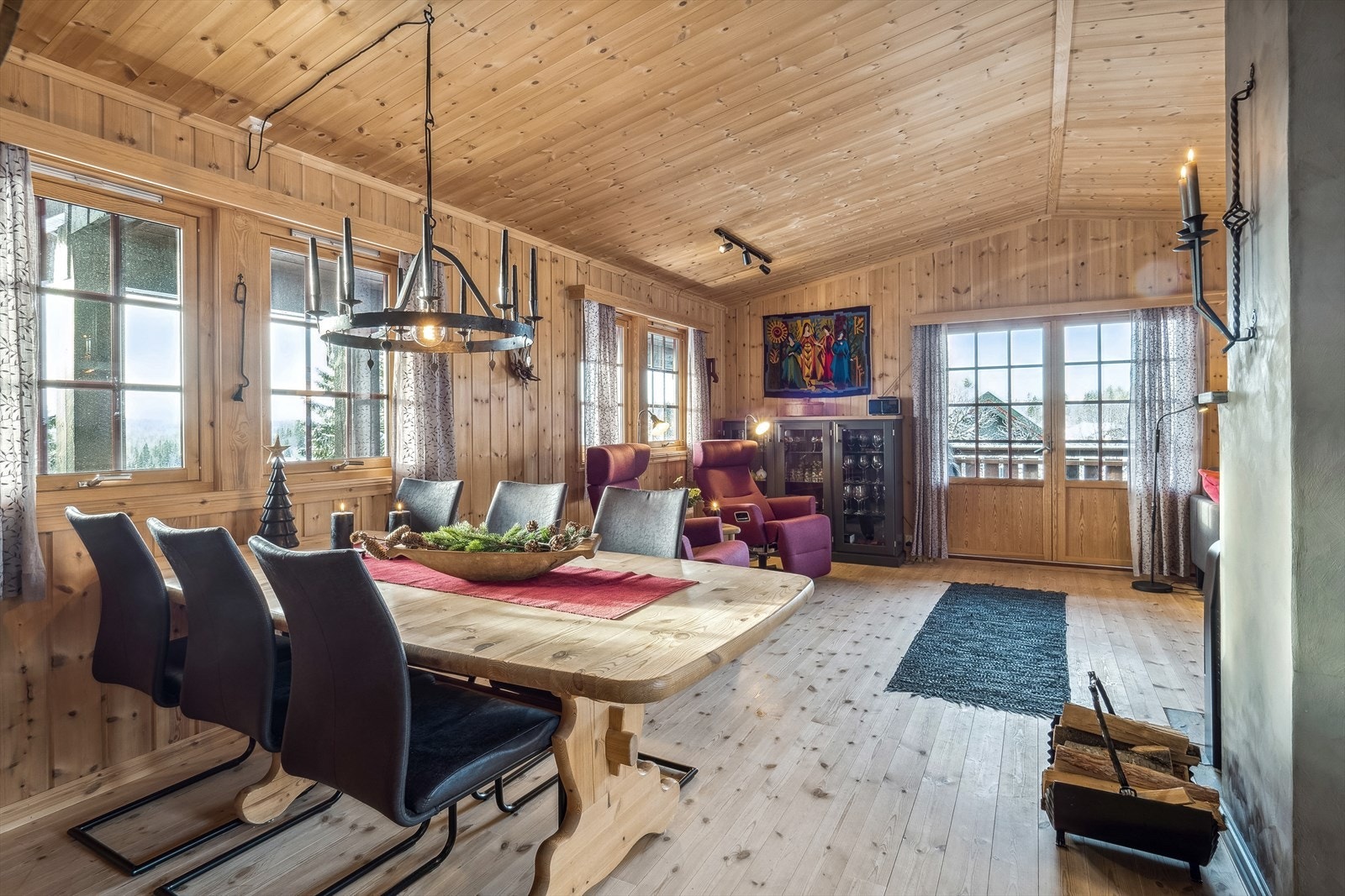 Stue med flere vindusflater som gir godt med dagslys inn i hytta. Galleribilde