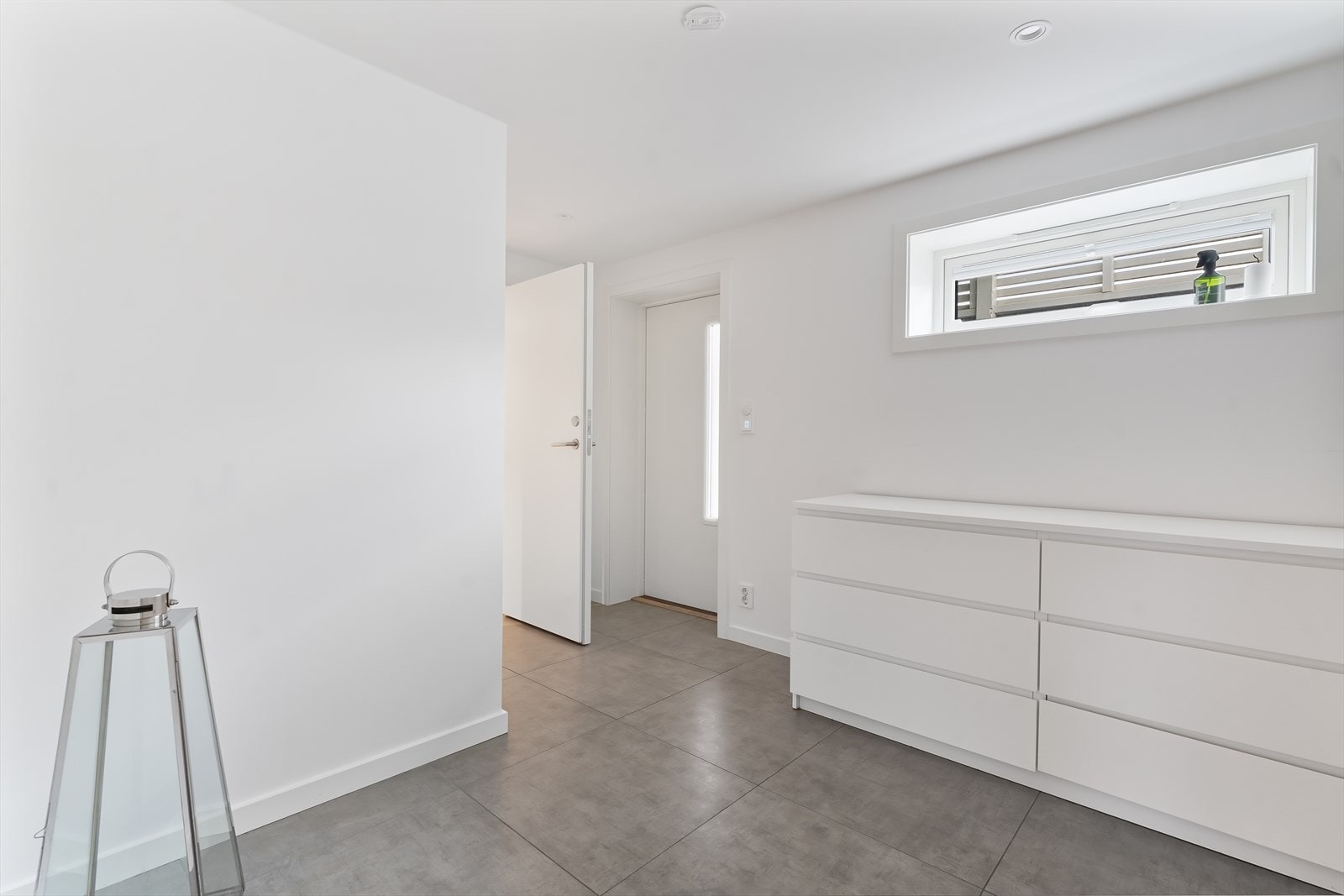 Underetasjen har egen inngang med flislagt gulv, lyse moderne farger og god plass til garderobe. Galleribilde