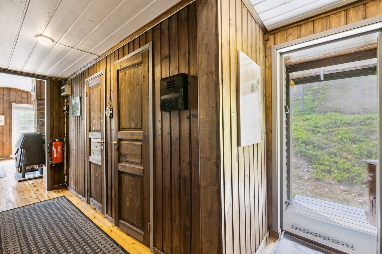 Her kommer man inn i en gang med brunmalt panel på veggene og lakkert furugulv. Gangen er romslig med god plass til å henge fra seg yttertøy og sko. Galleribilde