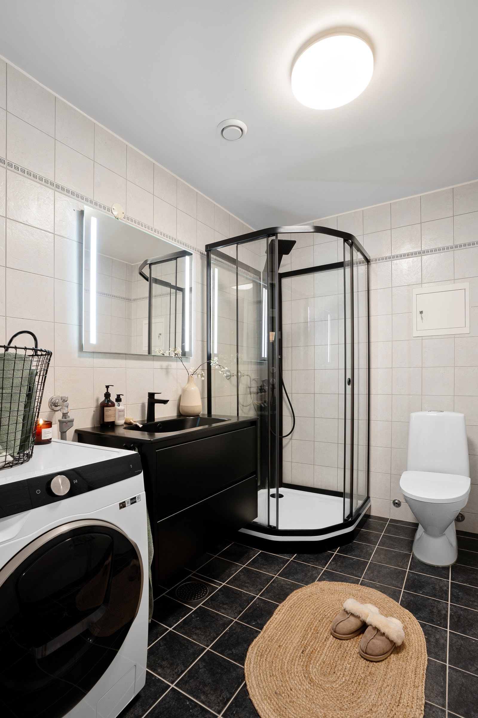 Badet har wc, dusjkabinett, baderomsinnredning med heldekkende servant i sort utførelse. Opplegg for vaskemaskin. Galleribilde