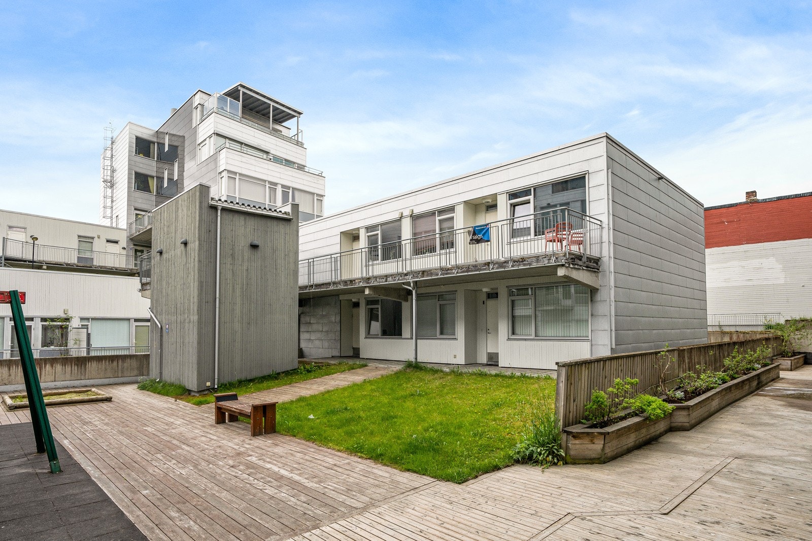 Pent opparbeidet felles uteområde med lekeplass. Det er trapp fra svalgangen og ned til uteområdet. Galleribilde
