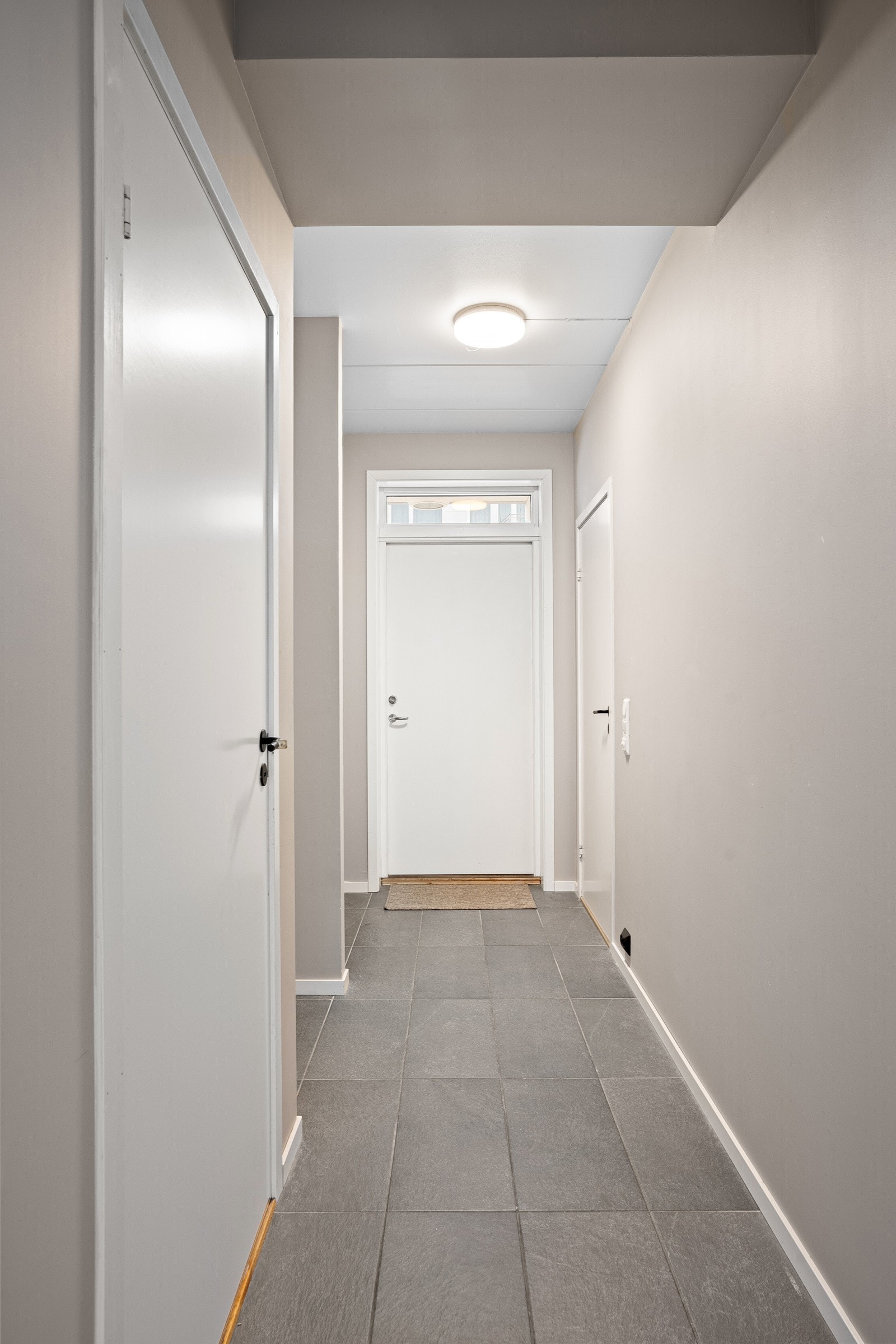 Innbydende og romslig entré/gang med fliser på gulv og gulvvarme Galleribilde
